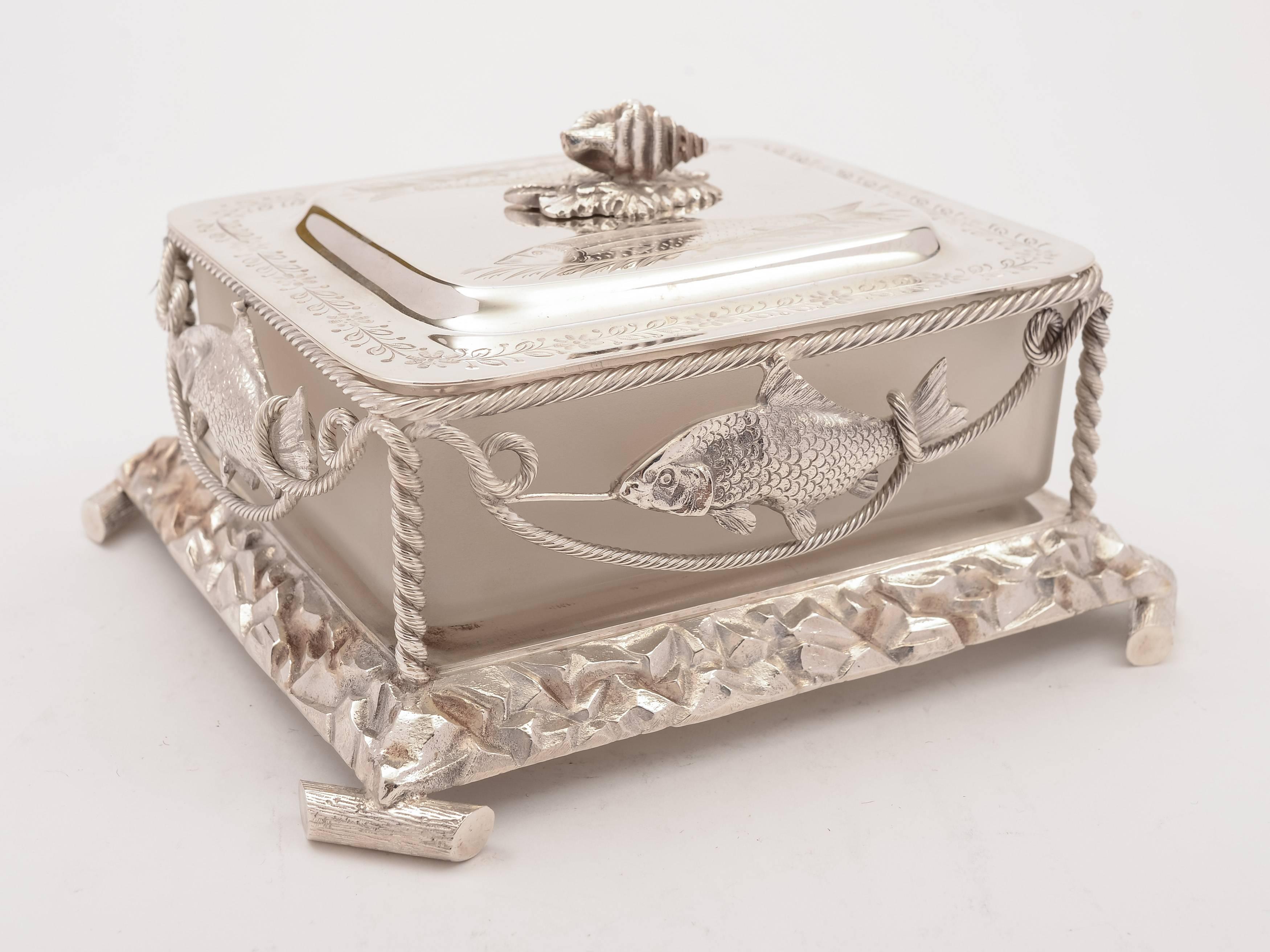 A beautiful and unusual English Victorian novelty silver plated butter dish with shell and fish decoration embossed to the outside, engraved decoration to lid and shell finial. Has frosted glass liner, circa 1880.

 

Measurements:
Height 3