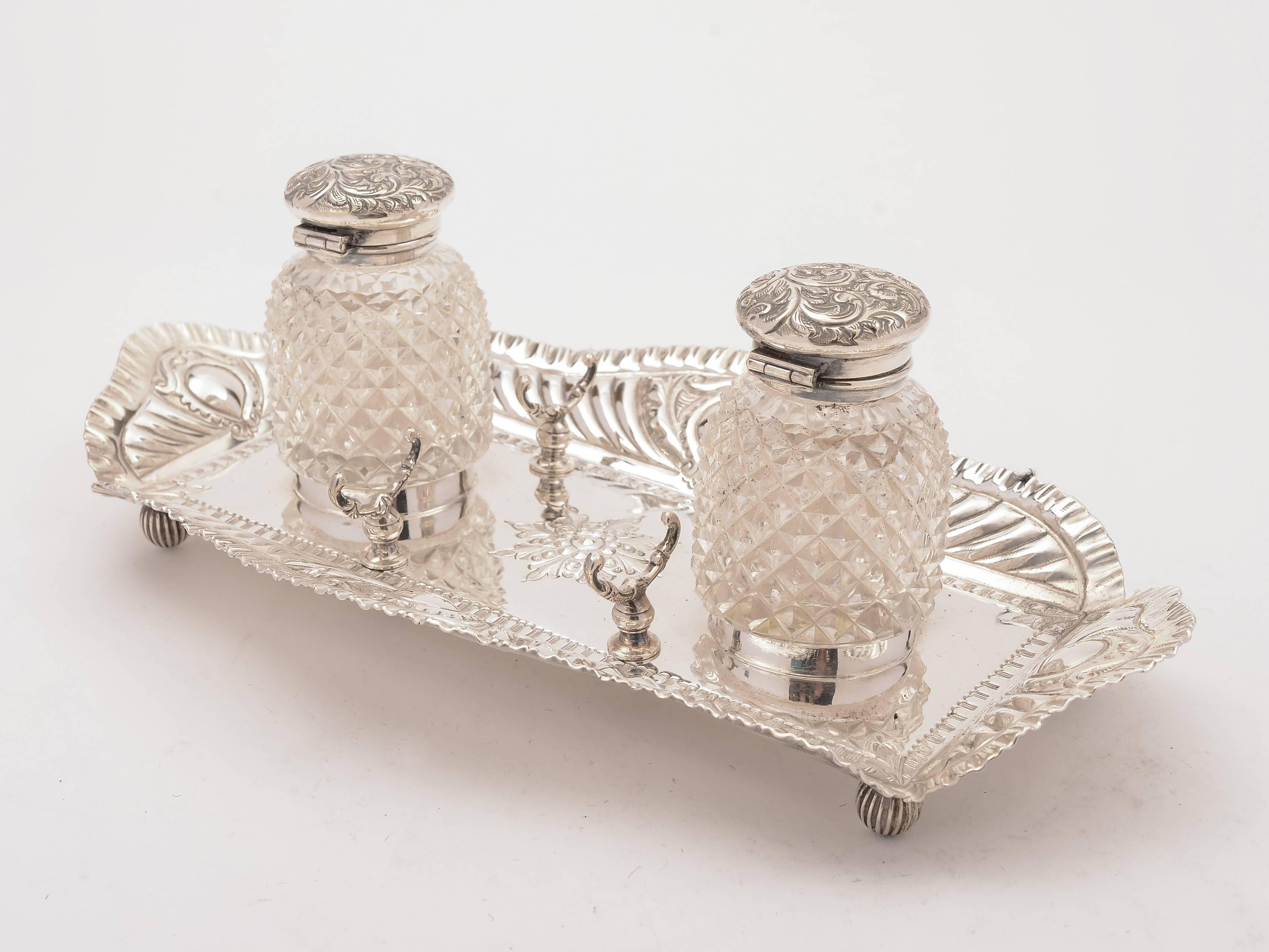 A good English Victorian silver plated double ink stand with pen holders to each side, embossed decoration and stands on 4 ball feet. Has a pair of cut-glass inkwells with embossed flip-up lids, circa 1890.

 

Measurements:
Total height 3 1/2