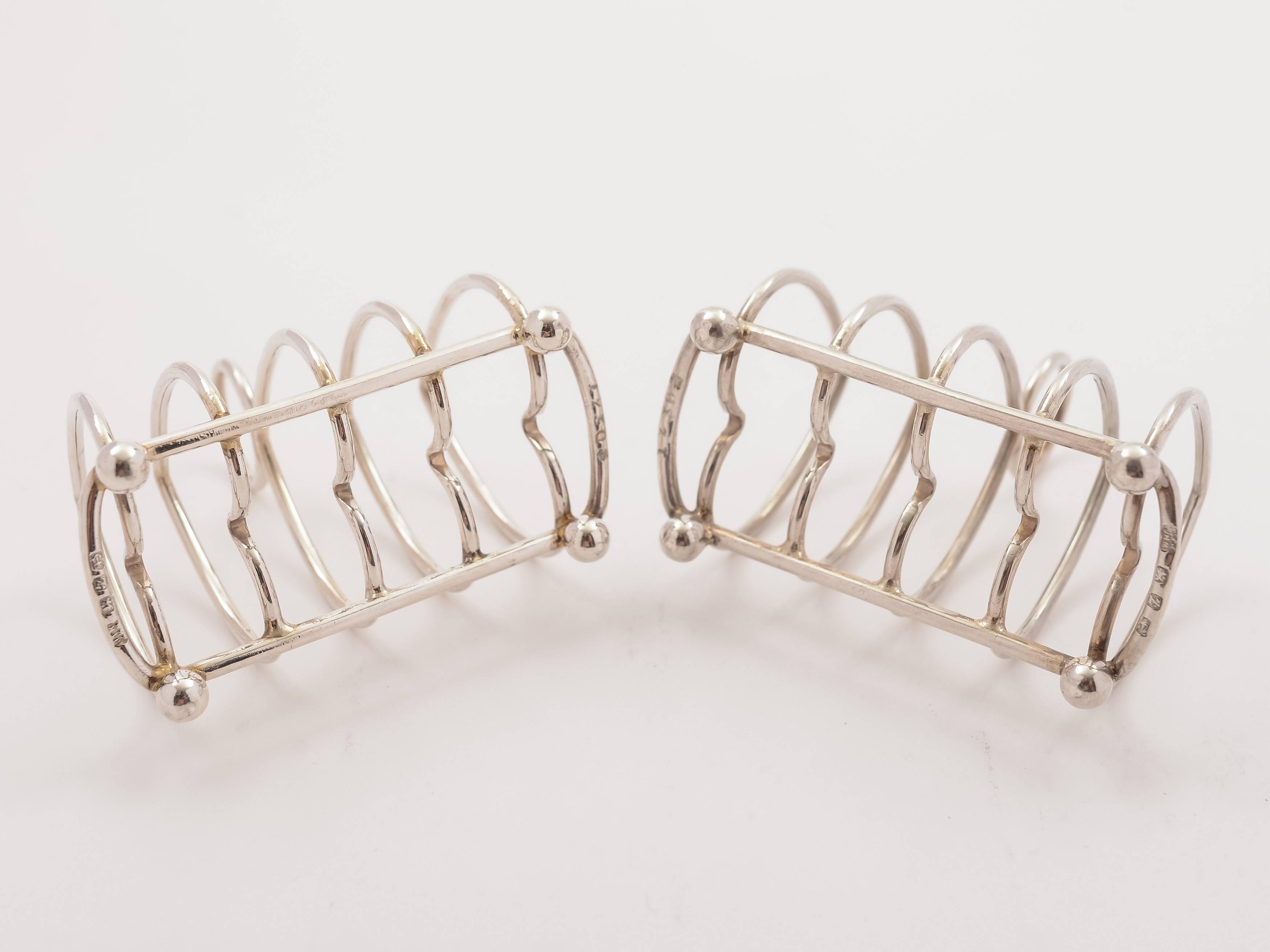 A fabulous pair of English Victorian silver caviar toast racks with heart shaped dividers and ring handle to top. Both stand of four ball feet. Hallmarked Birmingham 1899 and marked 'JTH over JHM' for the maker John Thomas Heath & John Hartshorne