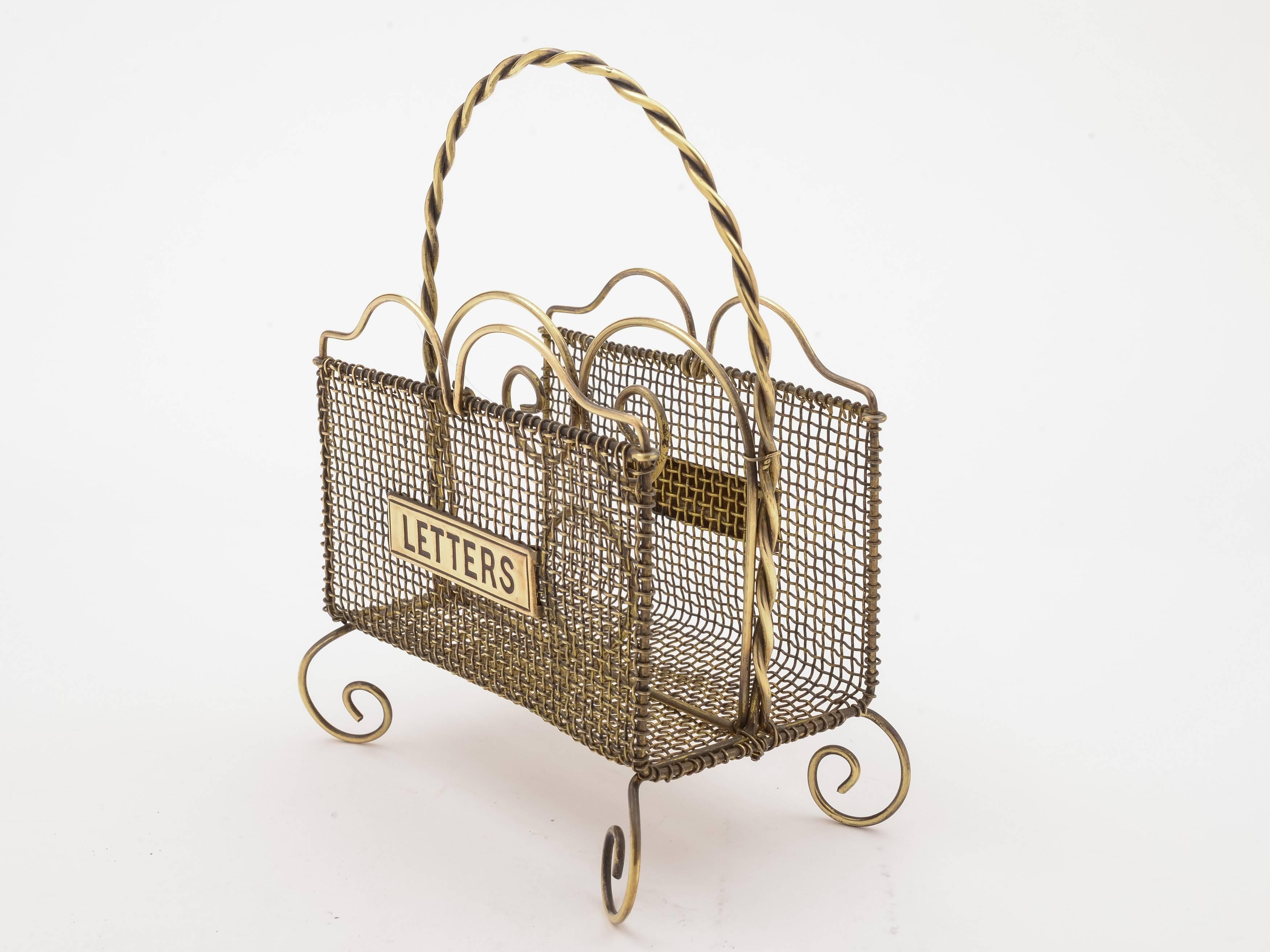 A lovely English Victorian brass wire-work letter rack with 'letters' plaque to each side, central carrying handle and two compartments for letters. Stands on four curled feet, circa 1890.

Measurements:
Height (including handle): 7