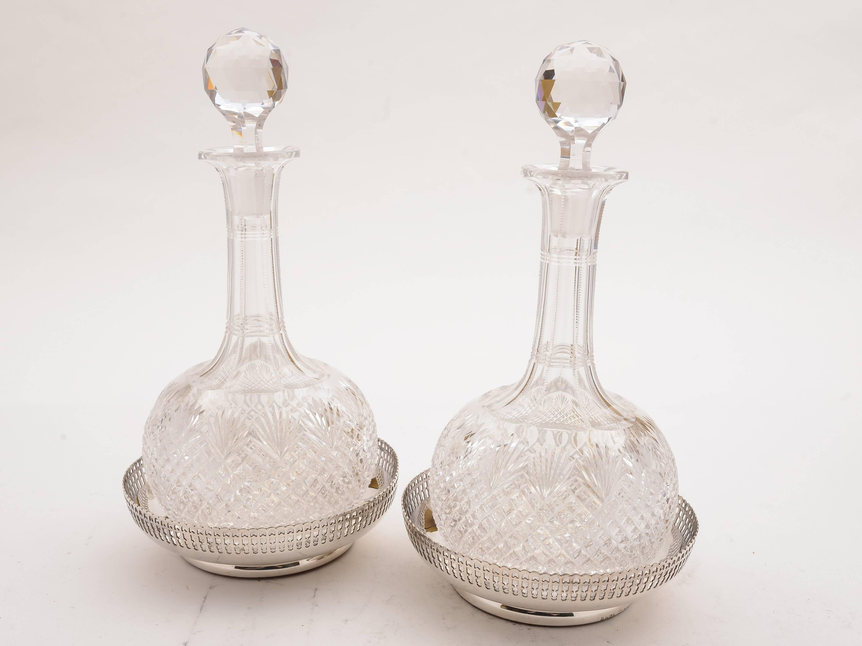 A gorgeous pair of English Victorian cut glass decanters with lovely cut decoration, original stoppers and silver plated decanter labels for sherry and brandy. Come with 2 silver plated and wooden-based coasters which have pierced galleries and