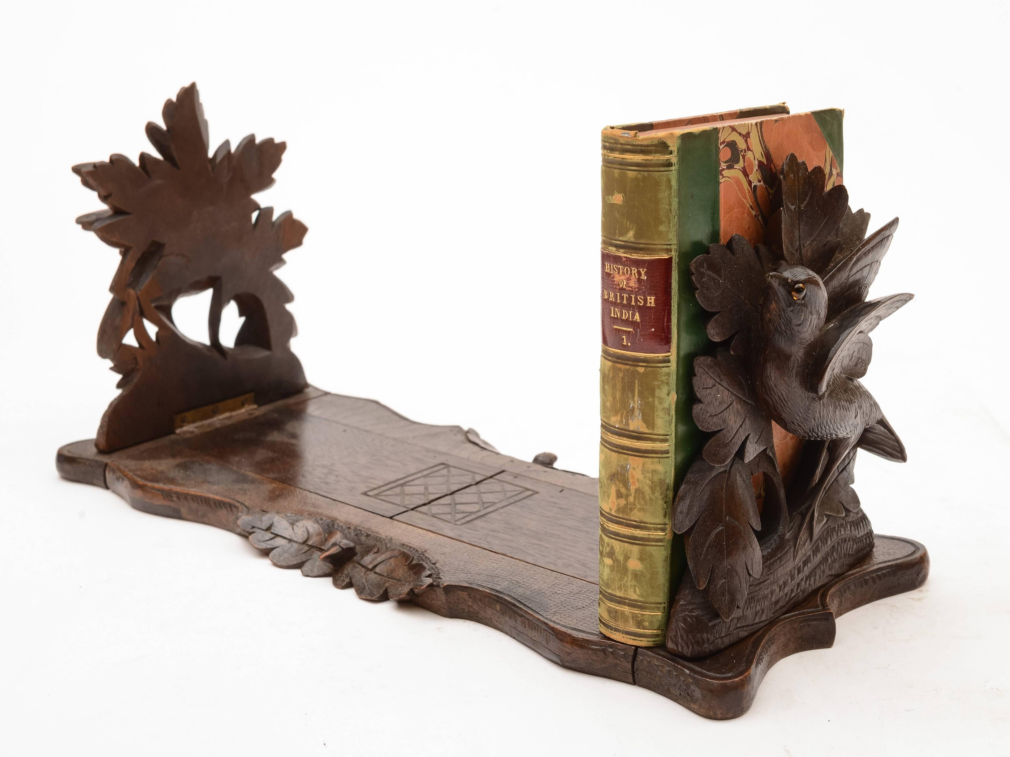 A gorgeous black forest carved sliding book rack with birds on tree branches to either end - birds have glass eyes. Circa 1900.

FREE worldwide delivery. 

Measurements:
Height (standing): 6 1/4" (approx 15.5cm)
Width: 5 1/4" (approx
