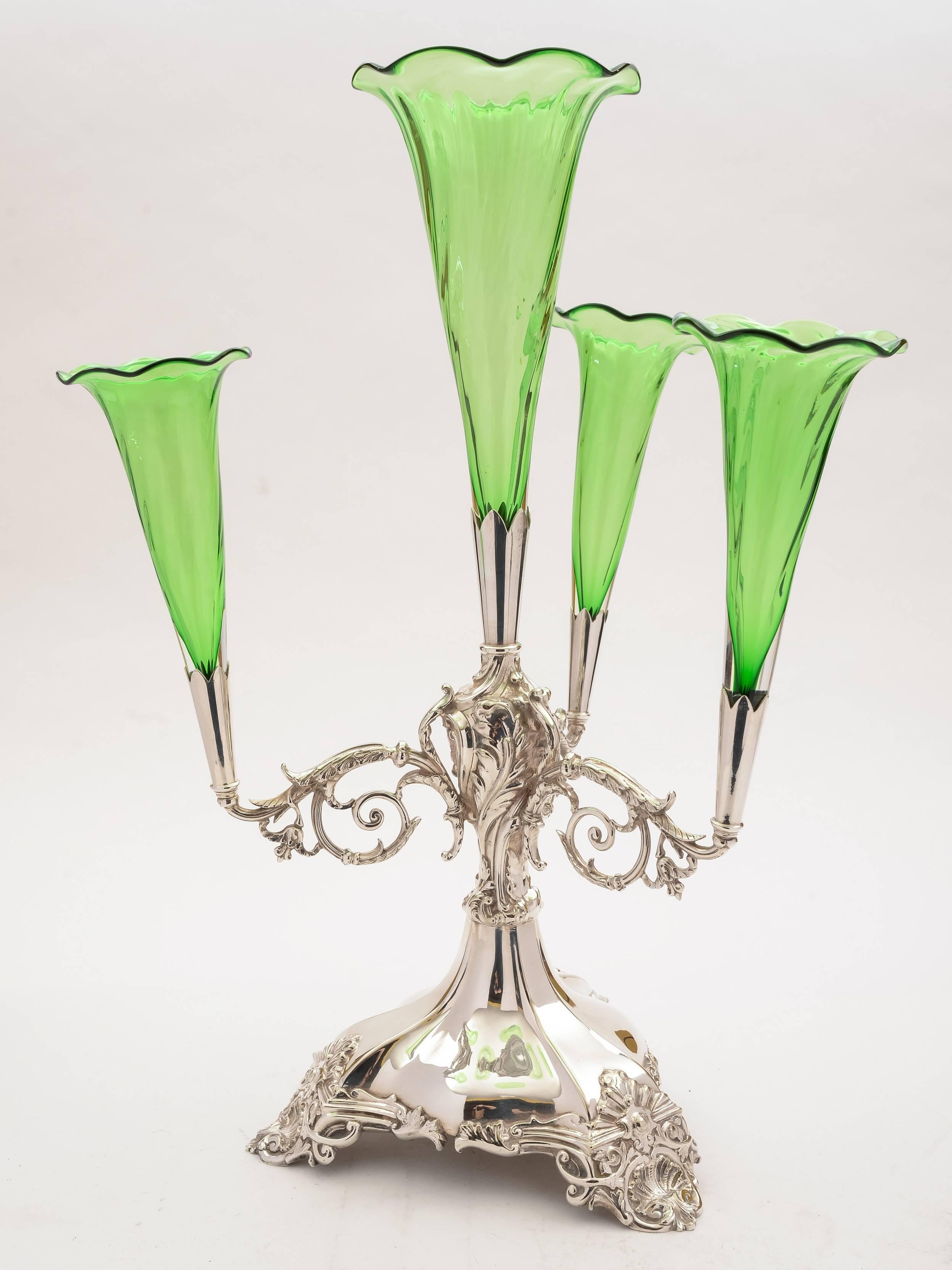 A superb English Edwardian silver plated eperne with embossed branches which hold 4 green wrythen-style glass trumpets. The base has embossed decoration to the 3 feet. Circa 1905.

FREE worldwide delivery. 

Measurements:
Height: 21" (approx
