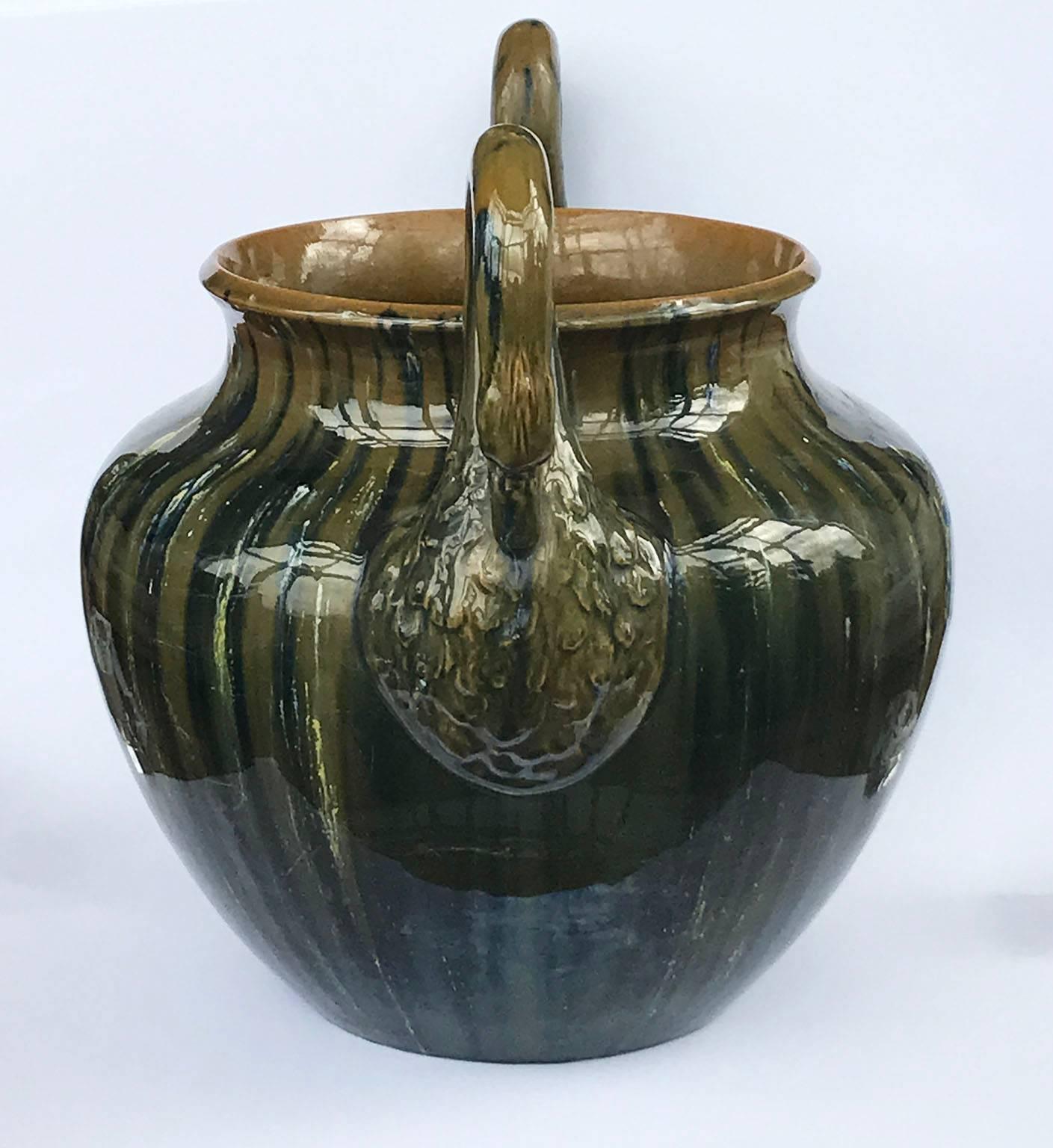 An elegant and rare Jerome Massier Majolica arts & crafts jardiniere, circa 1880, The bulbous body in rich, luminous and iridescent glazes with two arched swan necks and heads forming the handles.
Impressed marks to base.
Interestingly this design