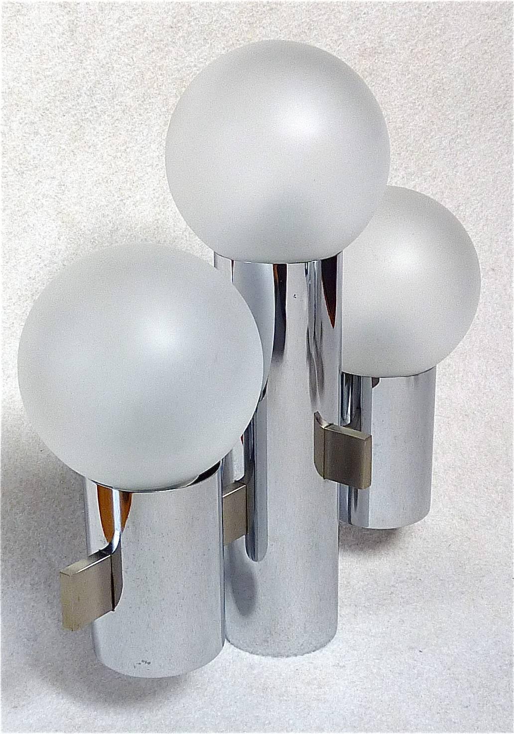 Great Italian pair of space-age wall lights or sconces designed by Gaetano Sciolari, circa 1960-1970 and manufactured by Sciolari, Rome, Italy. The lamps are made of chromed brass, brushed stainless steel and satin glass globes. Each sconce has