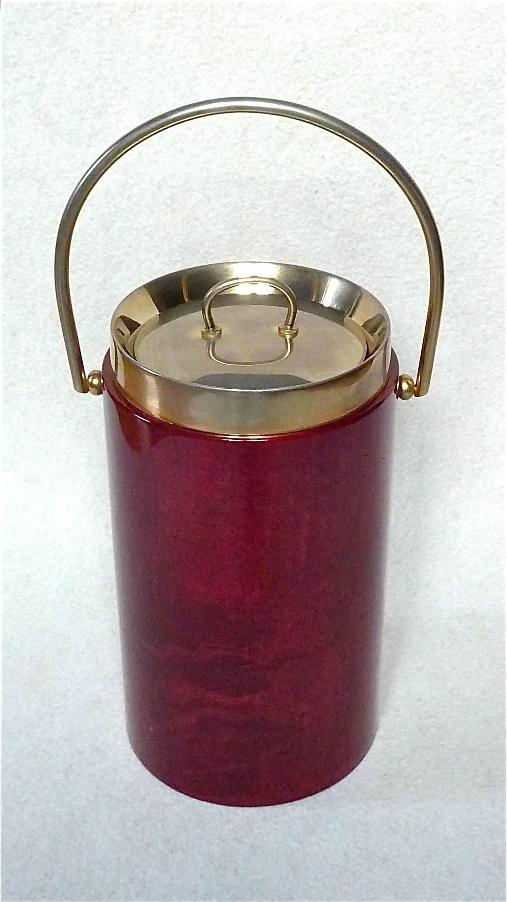 Rare and tall ice bucket or wine / champagne cooler with handle designed by Aldo Tura Milano, Italy, circa 1960-1970. It is made of a wooden corpus covered with a oxblood-red colored and varnished parchment or goatskin, a metal handle and lid and a