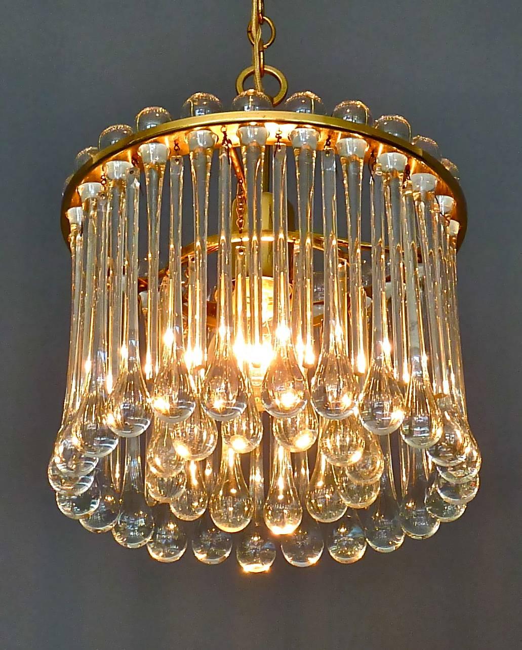 Gilt brass metal and crystal glass chandelier made by Palwa, Germany, circa 1960-1970. The chain-hanging length-adjustable chandelier has a gilt brass metal construction with lots of elongated Murano glass drops forming two glass rings. It bears the