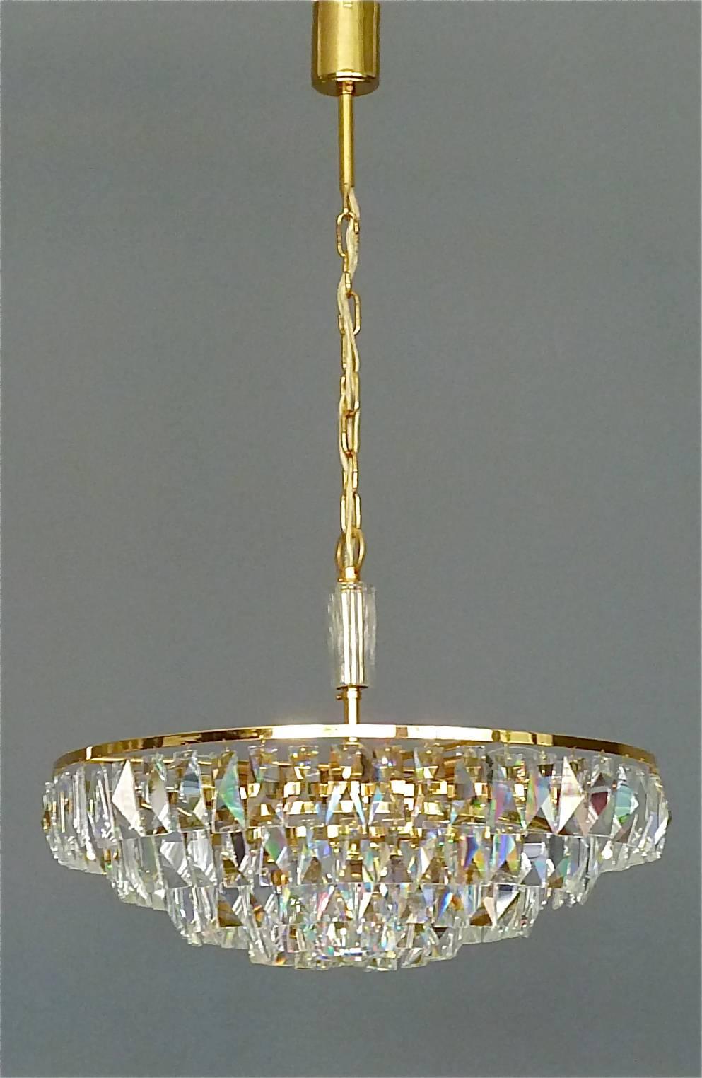 Fine large gilt brass and crystal glass chandelier made by Palwa, Germany, circa 1960. The chain-hanging length-adjustable chandelier has a crystal glass stem in the center and five gilt brass metal rings with lots of high lead hand-cut faceted