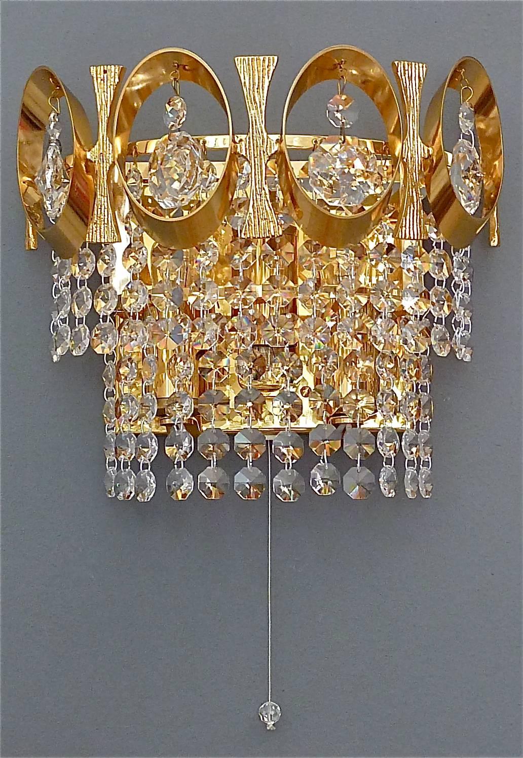 Pair of beautiful and precious wall lights or sconces by Palwa, Germany, circa 1960-1970. They are made of gilt brass and lots of sparkling faceted glass crystals with an oval crown application. The elegant and chic model is typical for Palwa,