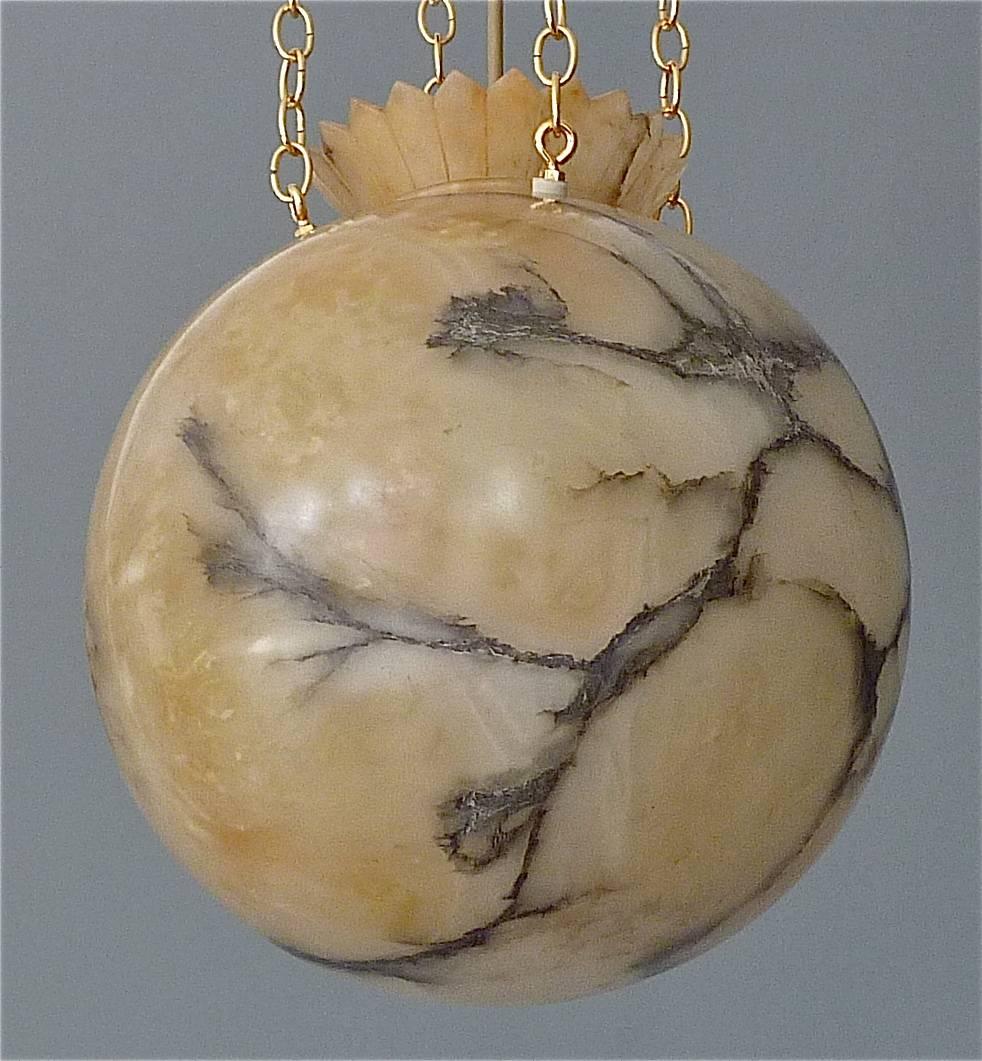 Unique carved creamy white beige alabaster globe crown chandelier with beautiful charcoal mineral veining in black and silver grey from the Art Deco period, France, circa 1920-1930. The high quality pendant light has a newly added handmade gilt