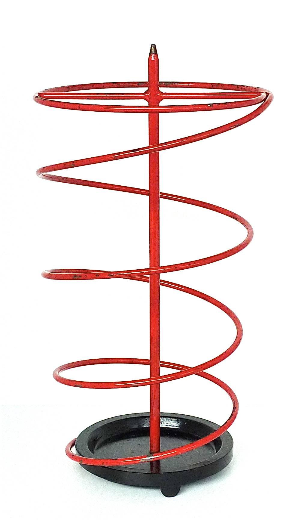 Sculptural rare French modernist iron umbrella stand in spiral shape in colors red and black, France, circa 1930-1950. Heavy black iron base with impressed number 10 and a red enameled tubular iron or steel spiral with visible losses of paint. From