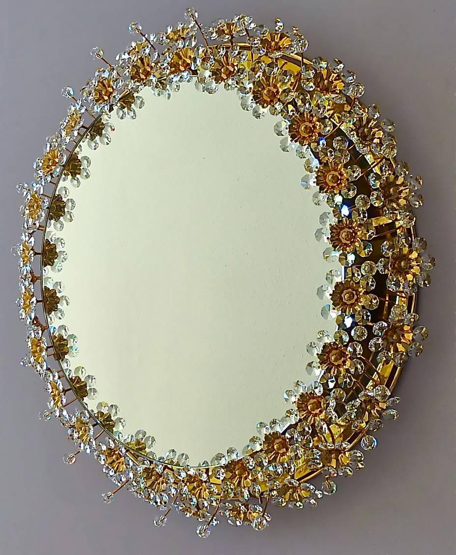 Amazing round gilt brass metal crystal glass backlit wall mirror made by Palwa, Germany, circa 1960-1970, documented in the Palwa sales catalog. The frame has lots of beautiful hand-cut faceted crystals in the shape of flowers which sparkle like
