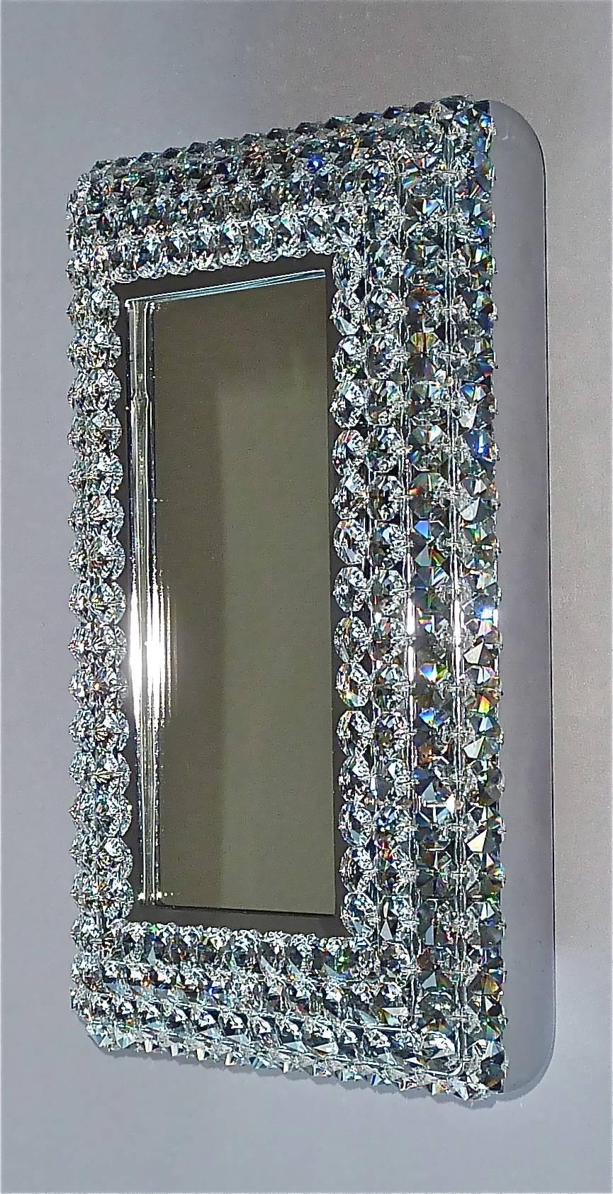 Beautiful petite chrome brass metal crystal glass backlit wall mirror made by Palwa, Germany, circa 1960-1970, documented in the Palwa sales catalog and signed at the back with Palwa company label with model number. The frame has lots of beautiful