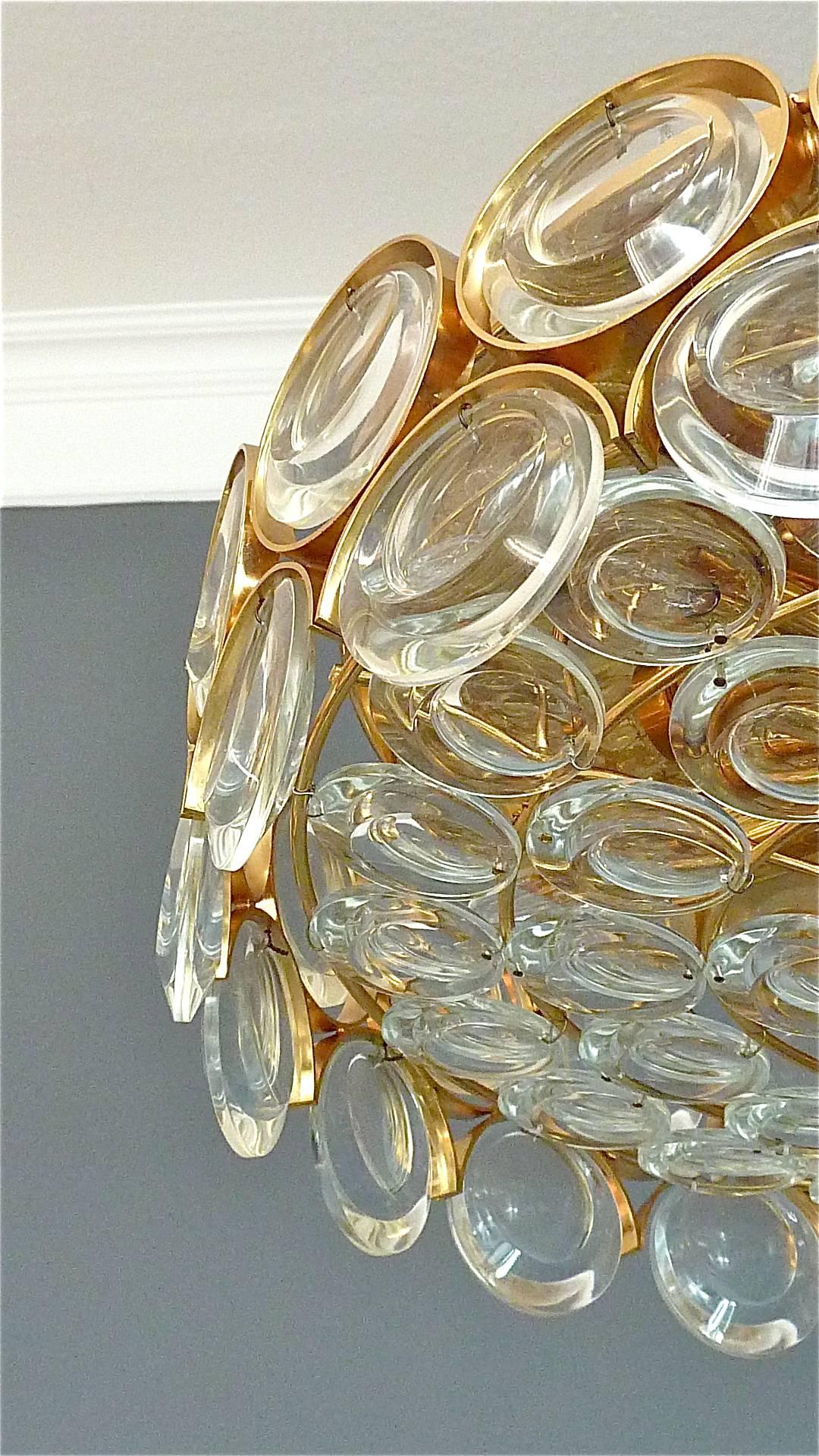A stunning midcentury gilt flush mount or ceiling chandelier with round polished optical crystal glass lenses manufactured by Palwa, Germany around 1960s-1970s. The beautiful hand-crafted chandelier with concentric circles in Op Art / Pop Art Style