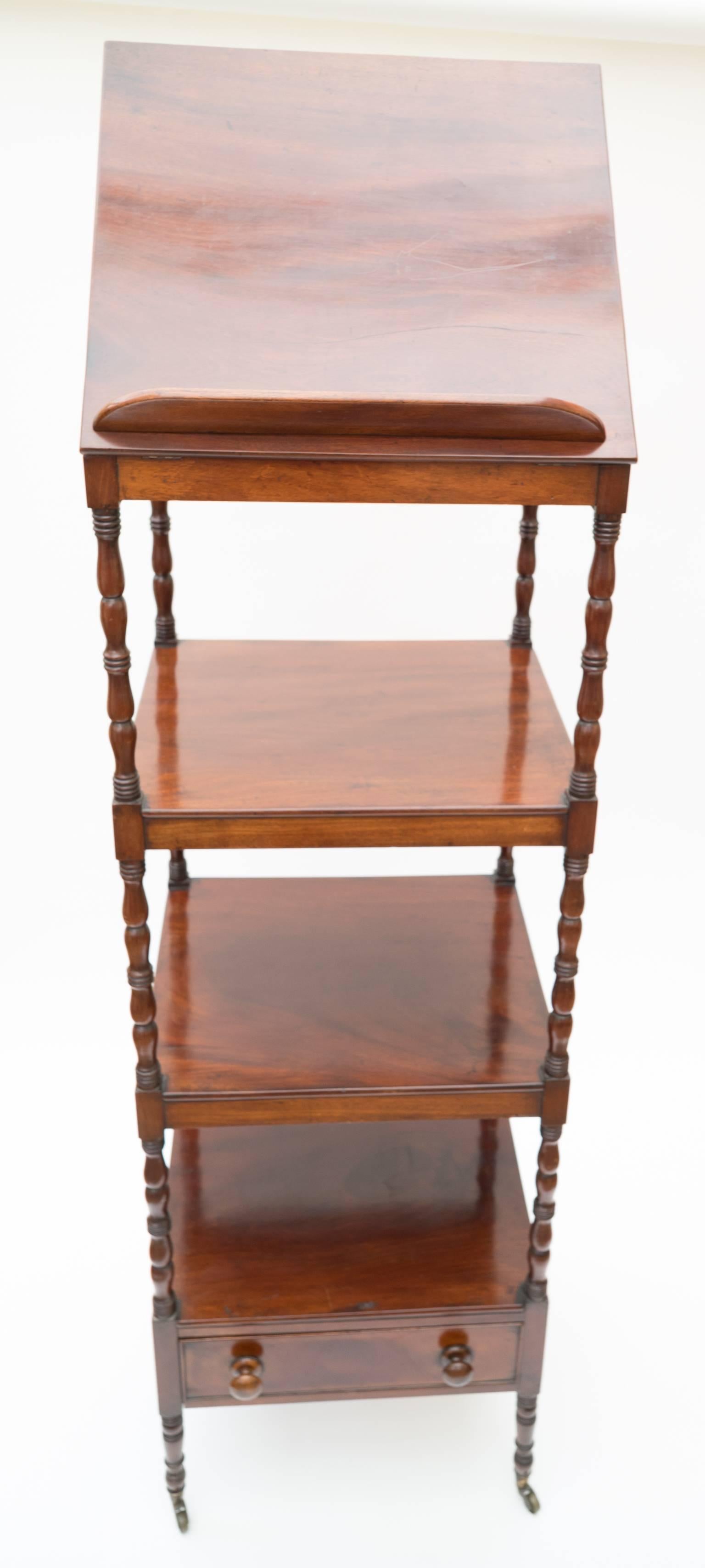 A Regency four-tier mahogany whatnot with a rising reading stand,
1820.

The lower platforms with fine turned uprights the lower shelf has a useful drawer below. 

Standing on brass casters.