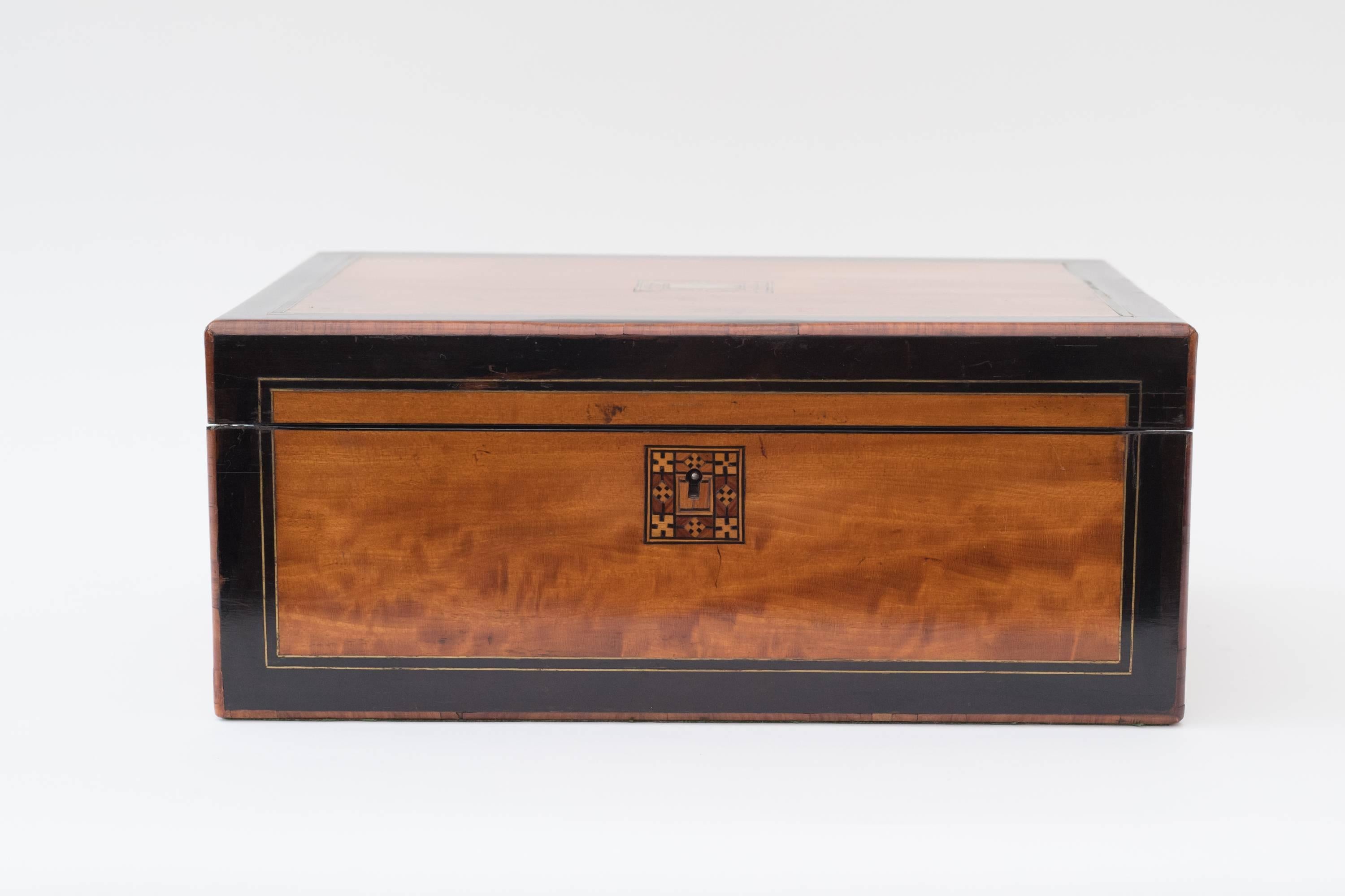 A satinwood lap desk inlaid with brass and tulipwood
with two original ink bottles.
    