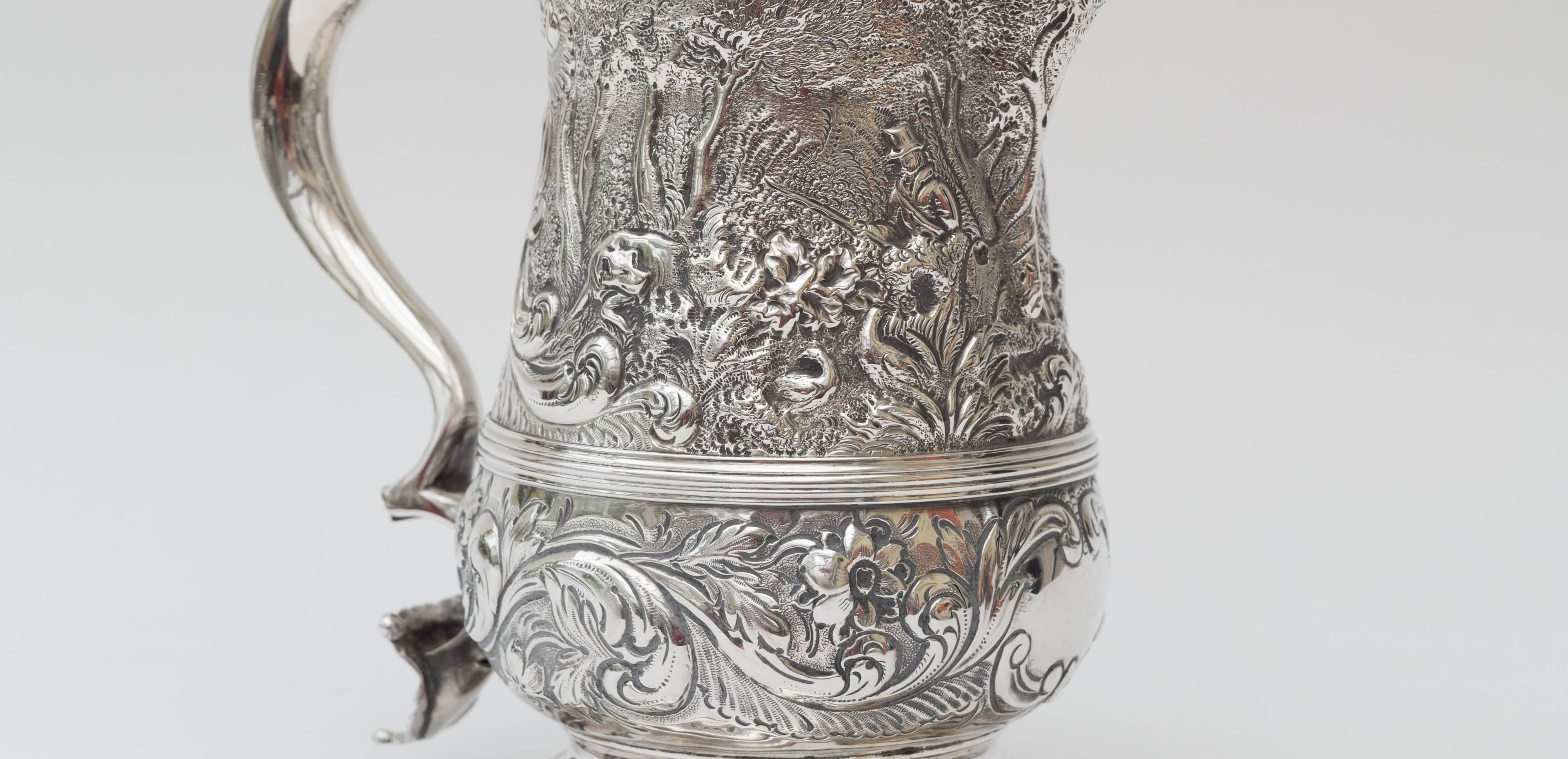 Silver tankard by William Caldecott 
The relief depicts a very detailed hunting scene including pointer dogs and men with guns in woodland.
Caldecott became a London silver smith in 1756
This piece is date marked letter 'K' 1765/6

Measures: