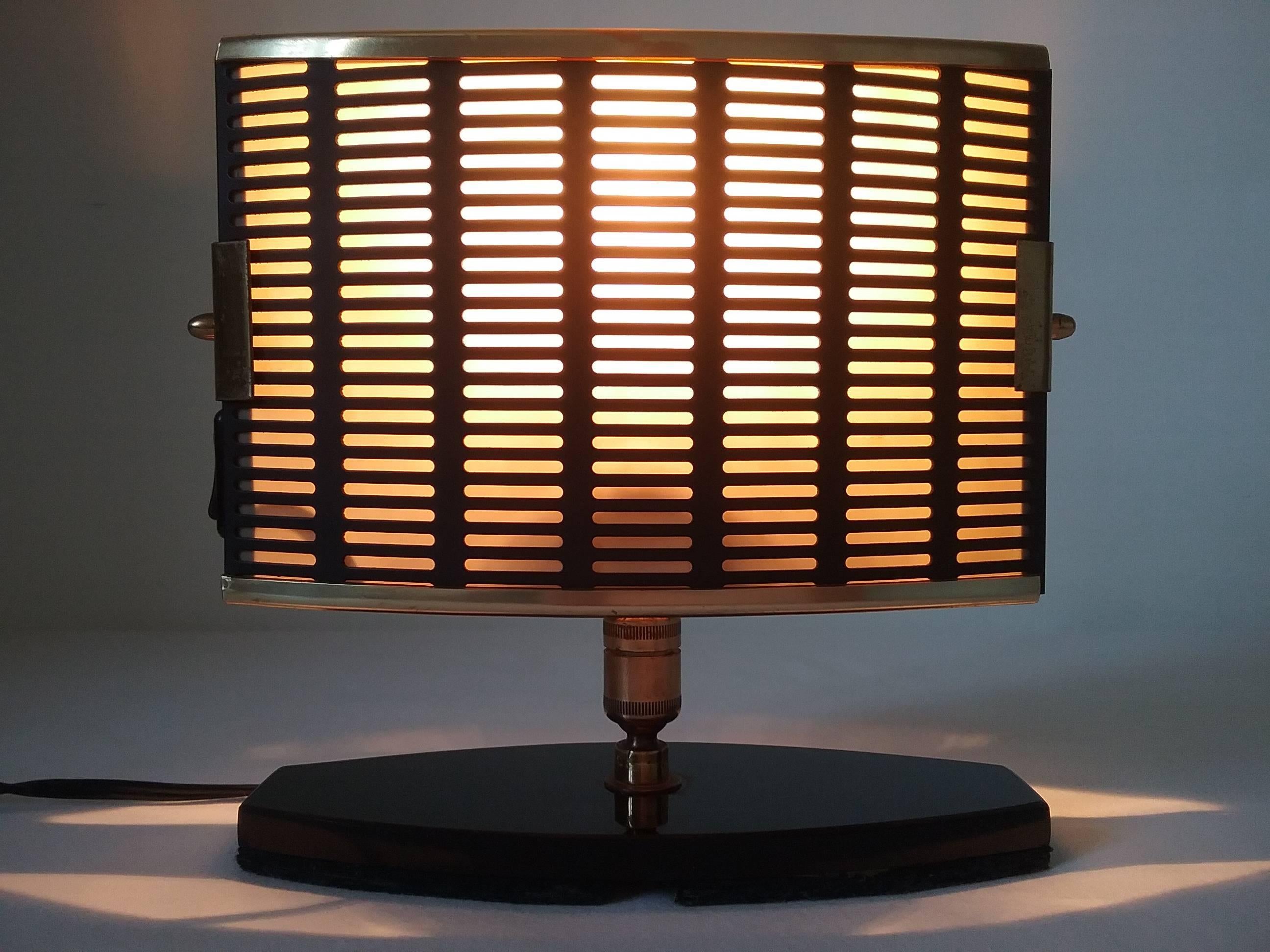 Useful table lamp with black perforated metal shade, mounted on two joints system. The base is made on black plastic with a foam sole stucked below.
An original Arlus documentation showing a similar lamp will be sent.
In working order with original