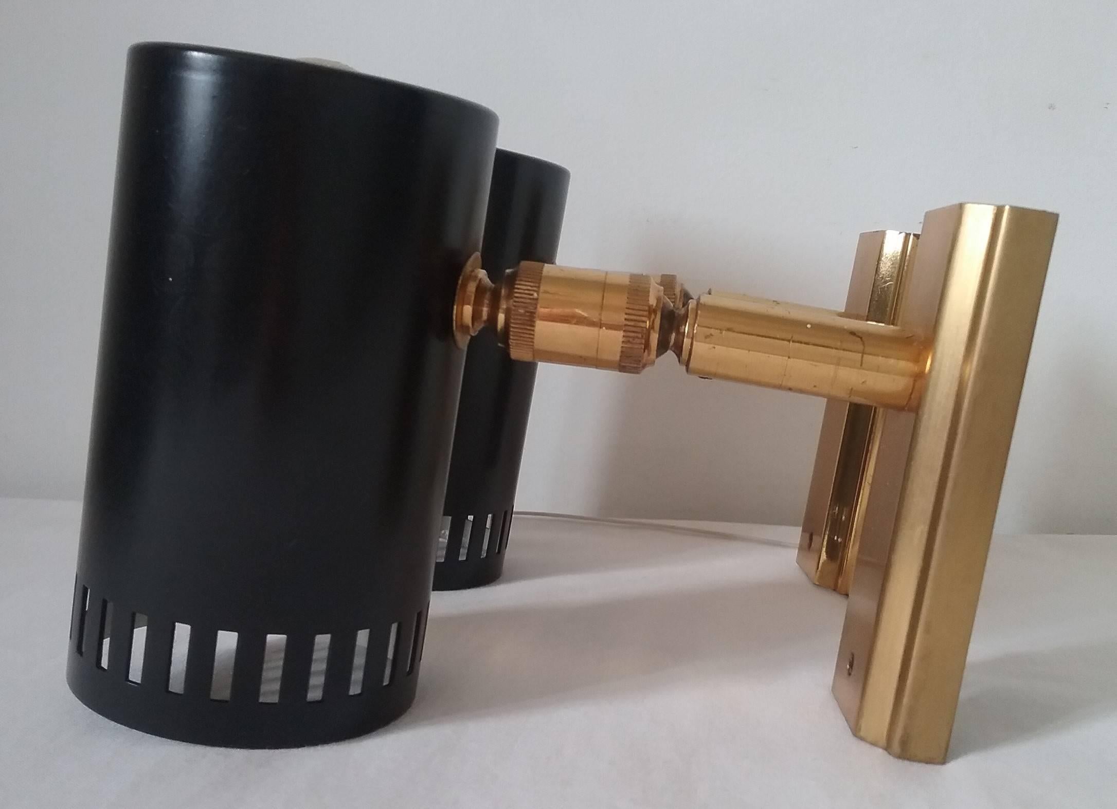 Authentic pair of wall lights Tube, mounted on a rectangular gilded metal base.
Adjustable wall sconces thanks to a double rotating joints system.
Designed in 1950s, similar work to Jacques Biny or Gino Sarfatti
Black paint and gilded metal are