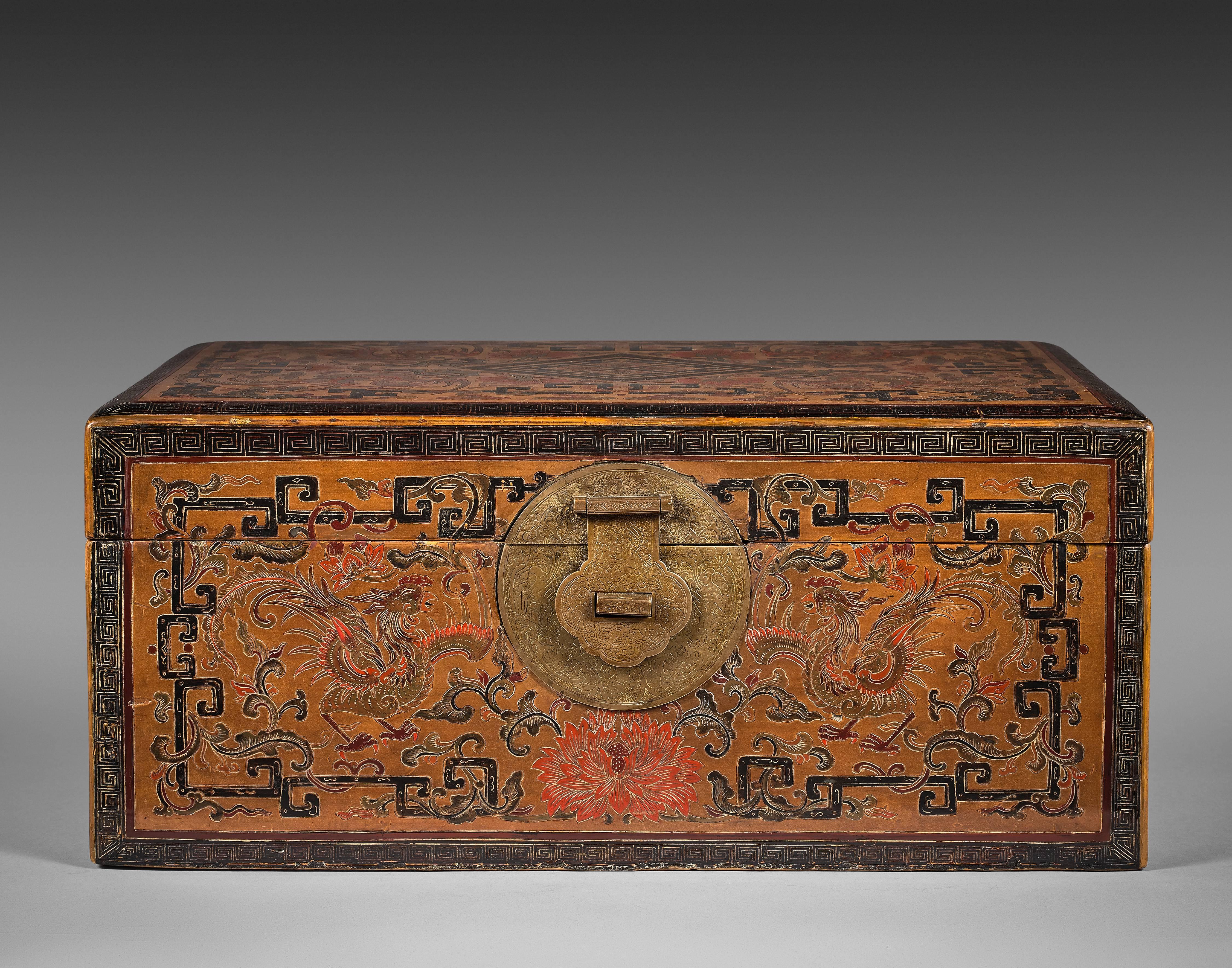 The coffer with an ocher yellow lacquered ground, engraved with phoenix, birds flyng among the clouds, foliage and flowers. The decoration also with keyfrets and stylized kui dragons patterns. The patterns highlighted with red, black, brown and
