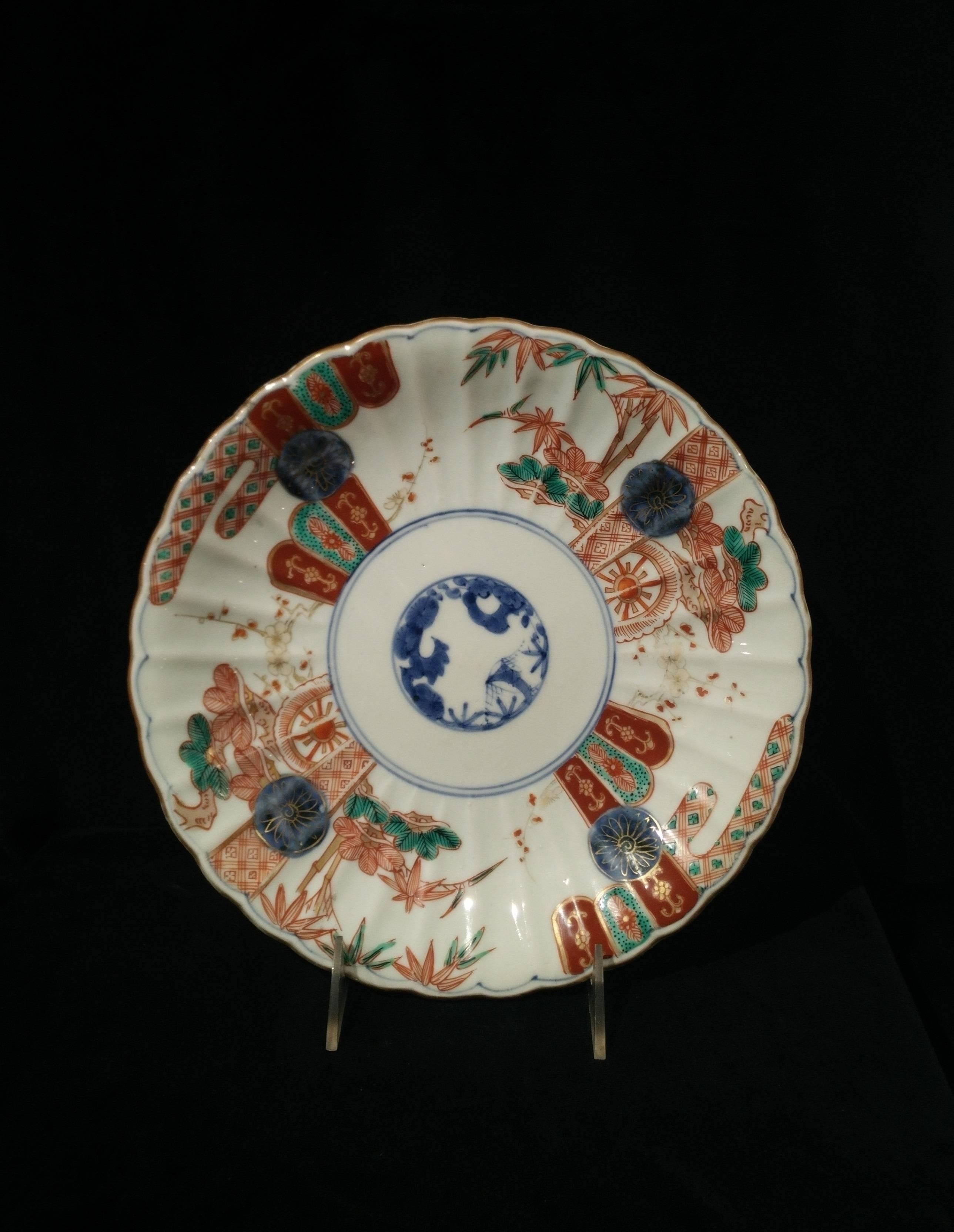 The chrysanthemum shaped plate with a central medallion in underglaze blue depicting pine, prunus and bamboo. The cavetto decorated in overglaze red, green and gold with pine, prunus and bamboo alternating with textile patterns.