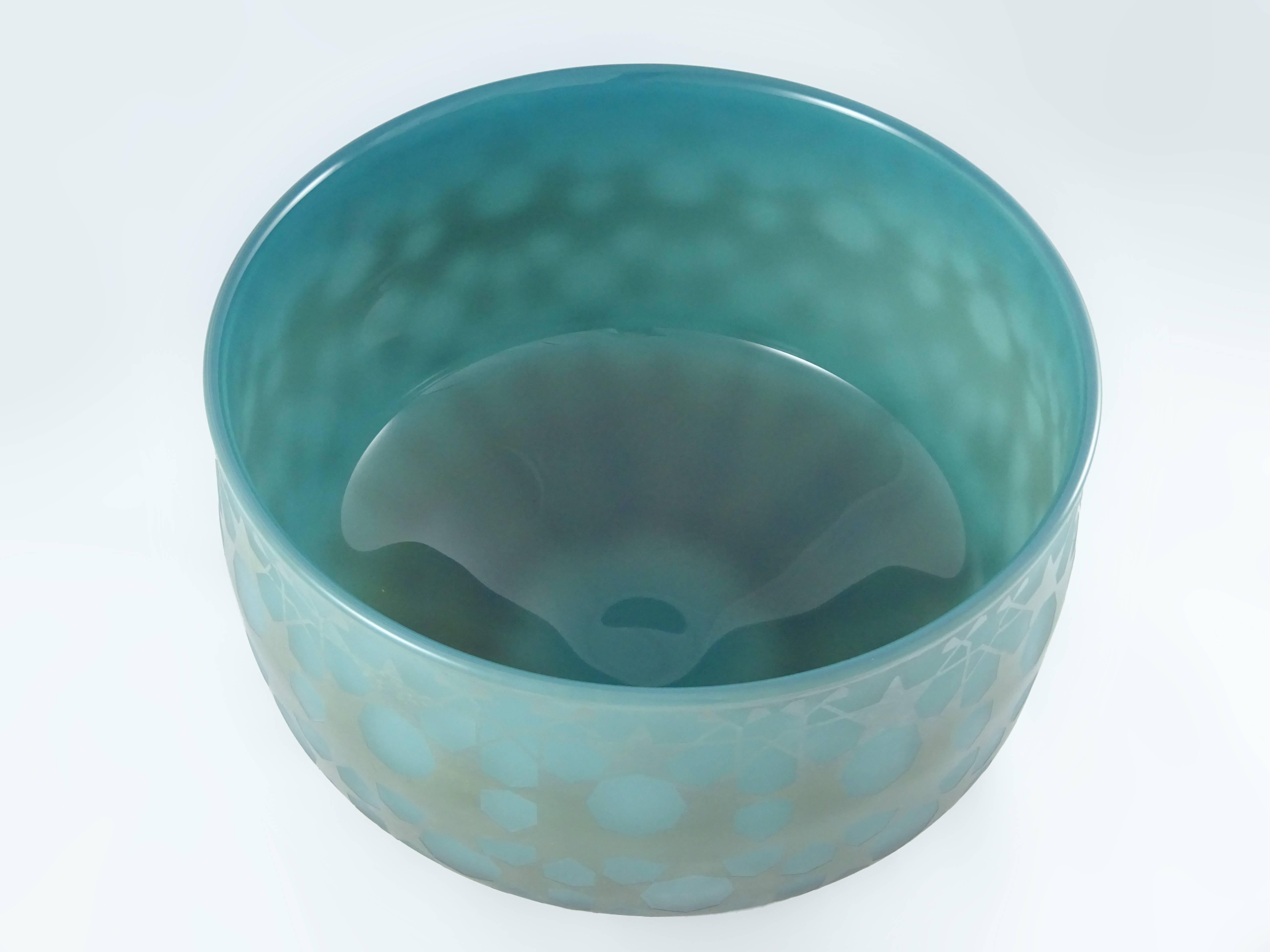 Blown glass bowl or vessel shaped sculpture. Ocean green semi translucent glass with a matte sandblasted glass decorations on the outside. During the final stage of creating this wonderful glass sculpture, the decorative pattern was created by