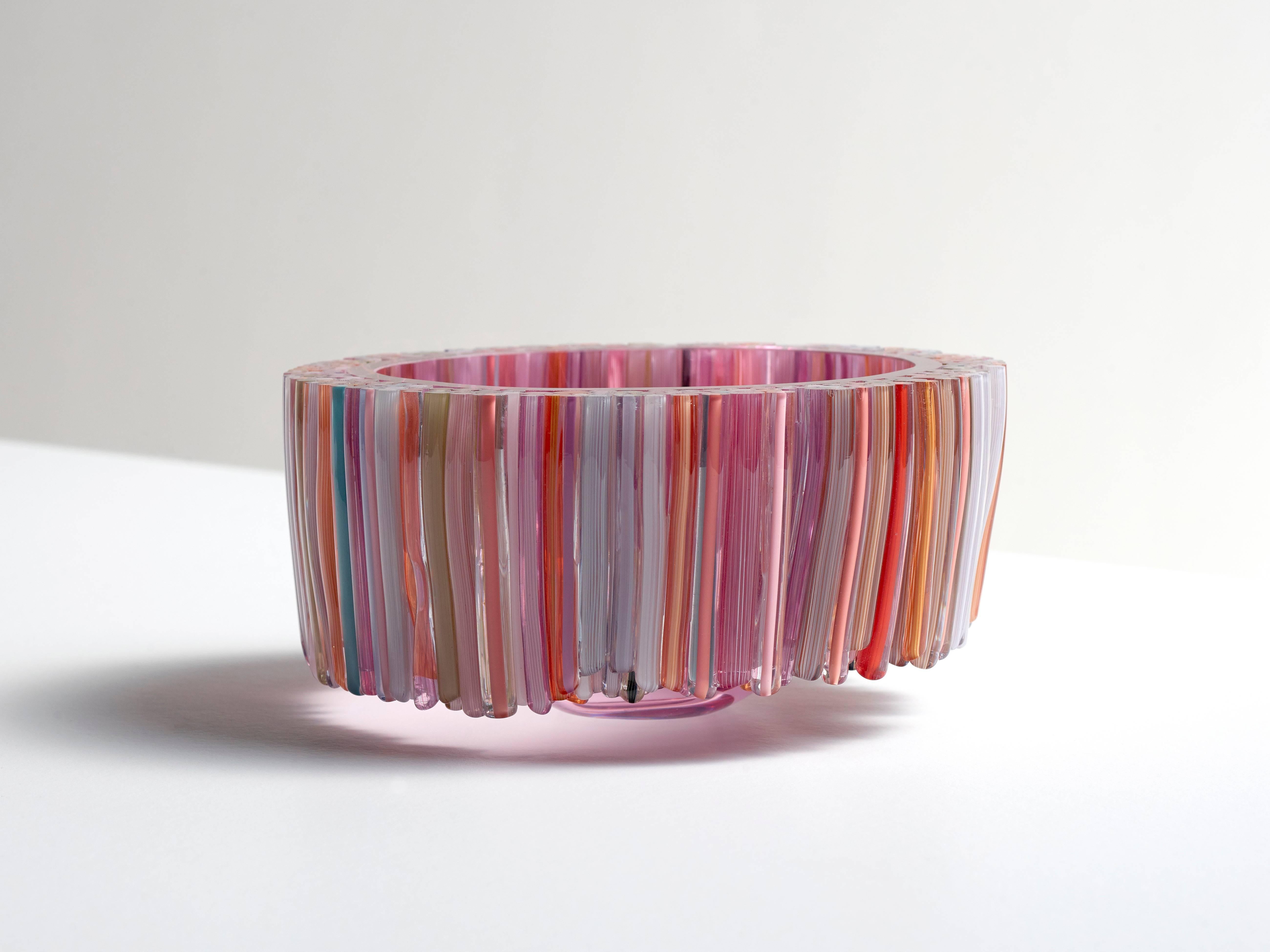 This beautiful blown glass red bowl is decorated with handcrafted glass threads that are melted to the body of the glass vessel. The many colors of the threads like, green, pink, blue, orange and white are stylishly combined, resulting in a playful