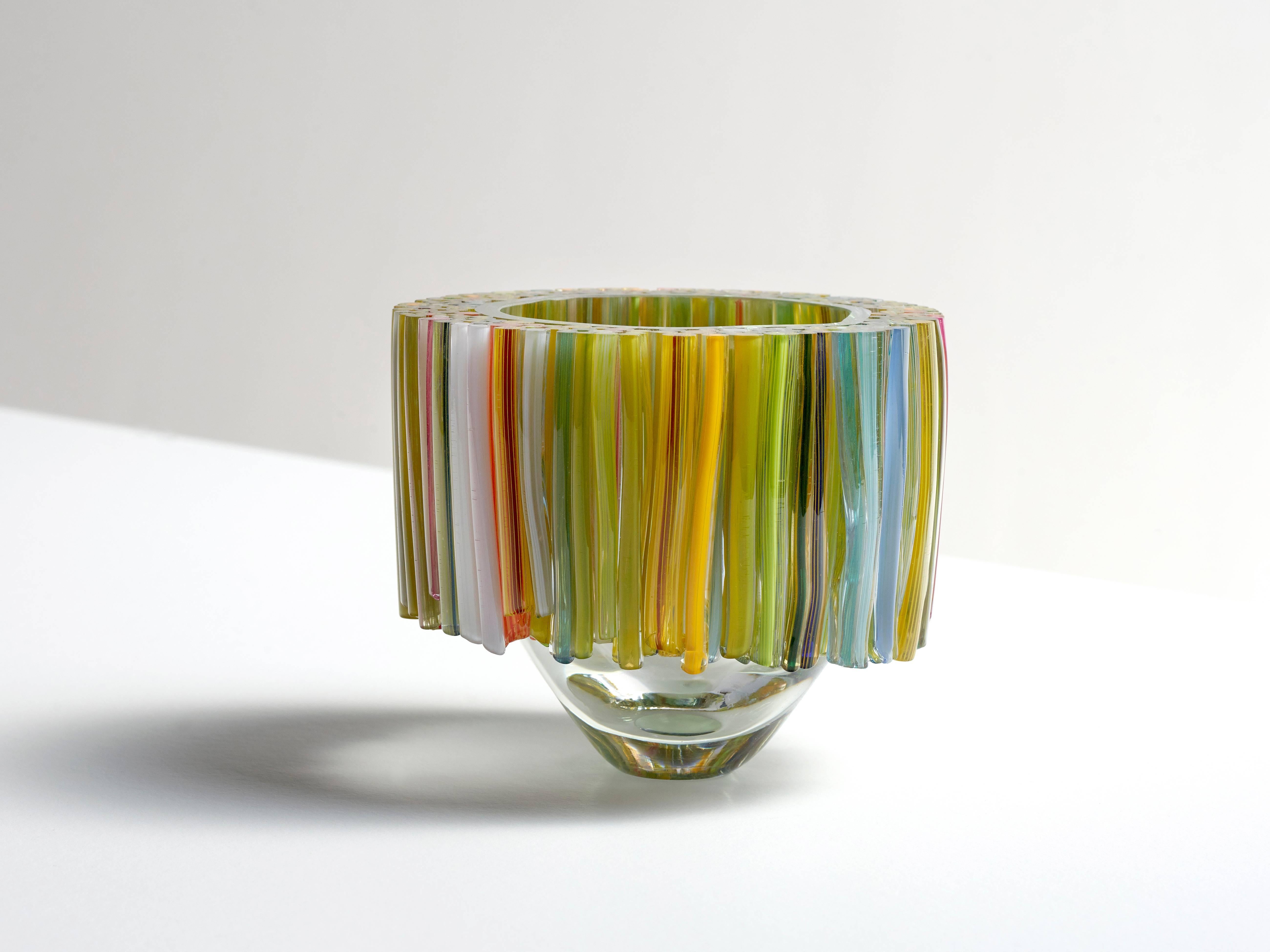 This beautiful clear blown glass bowl is decorated with handcrafted glass threads that are melted to the body of the glass vessel. The colors of the threads are in different shades of green and yellow, but also with some hidden highlights in pink,