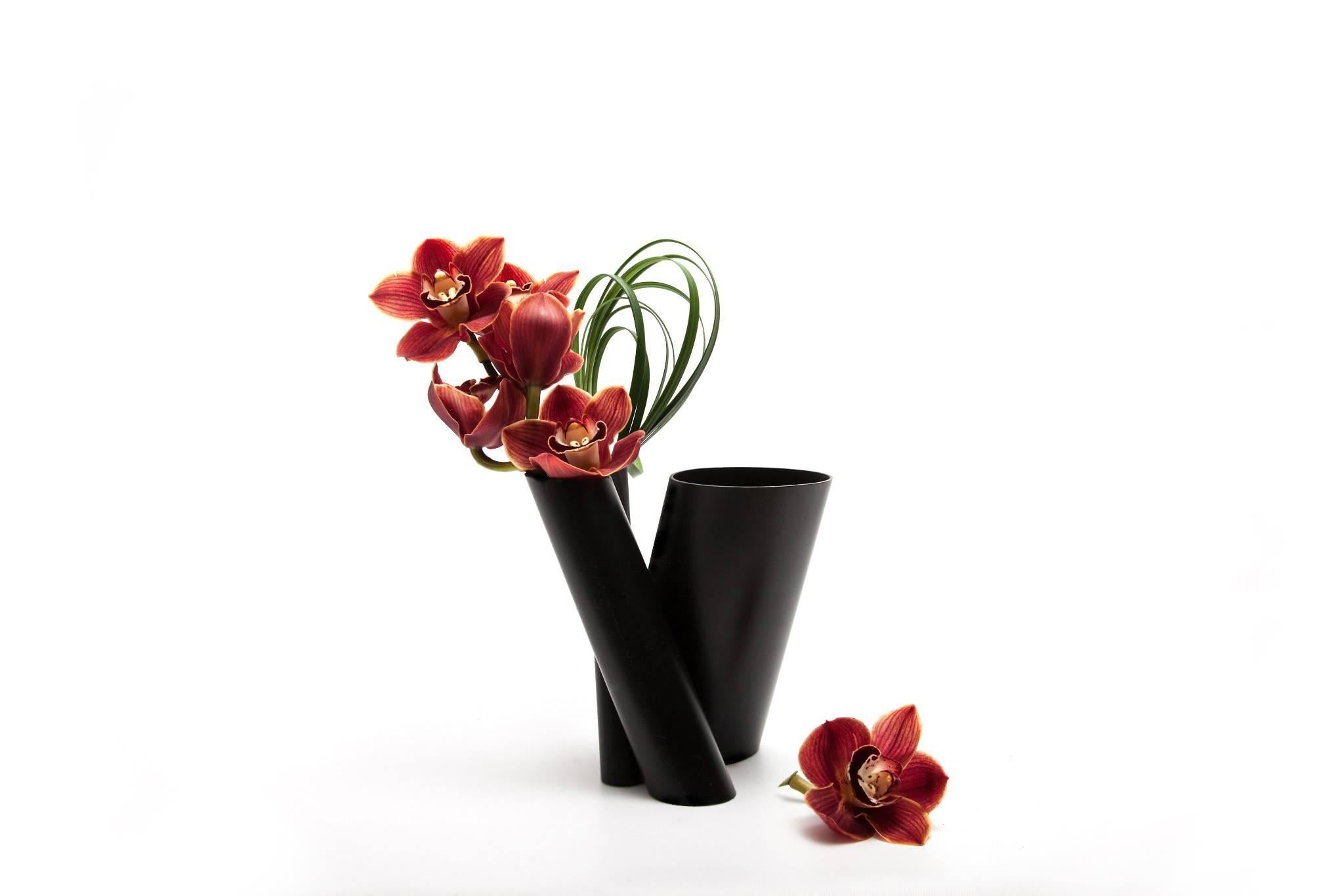 Three vases in one, composed of a series of black minimal hand-painted stainless steel tubes in various dimensions and cut on the bias, the contemporary Bana Triple vase can uniquely accommodate a single stem to full flower arrangements separately