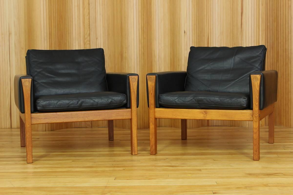 Pair of Hans Wegner teak and black leather lounge chairs model no. AP62 manufactured by A P Stolen, Denmark, 1960.

Wonderful examples of this Hans Wegner design.