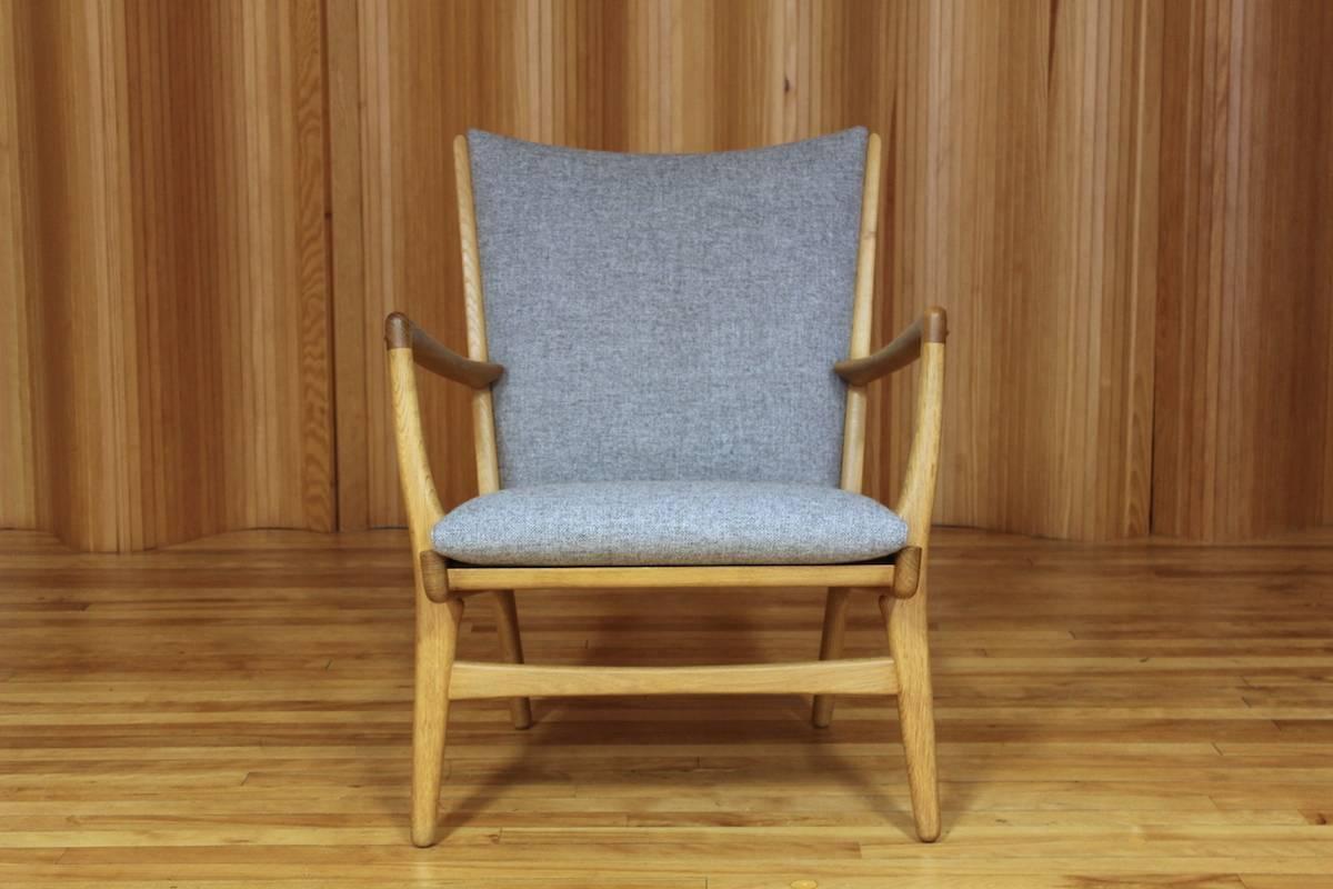 Hans J Wegner oak lounge chair model no. AP-16 manufactured by AP Stolen, Denmark, 1951.

The solid oak frame is a lovely color with stunning grain. Structurally strong. The new seat and back cushions have been re-upholstered in Kvadrat