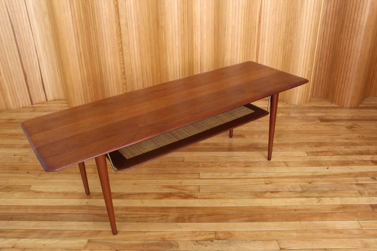 Description: Solid teak coffee table with canework shelf - model no. 516.

Designer: Peter Hvidt & Orla Mølgaard-Nielsen

Manufacturer: France & Son, Denmark

Date: circa 1956

Dimensions: Length 148cm; depth 50.5cm; height