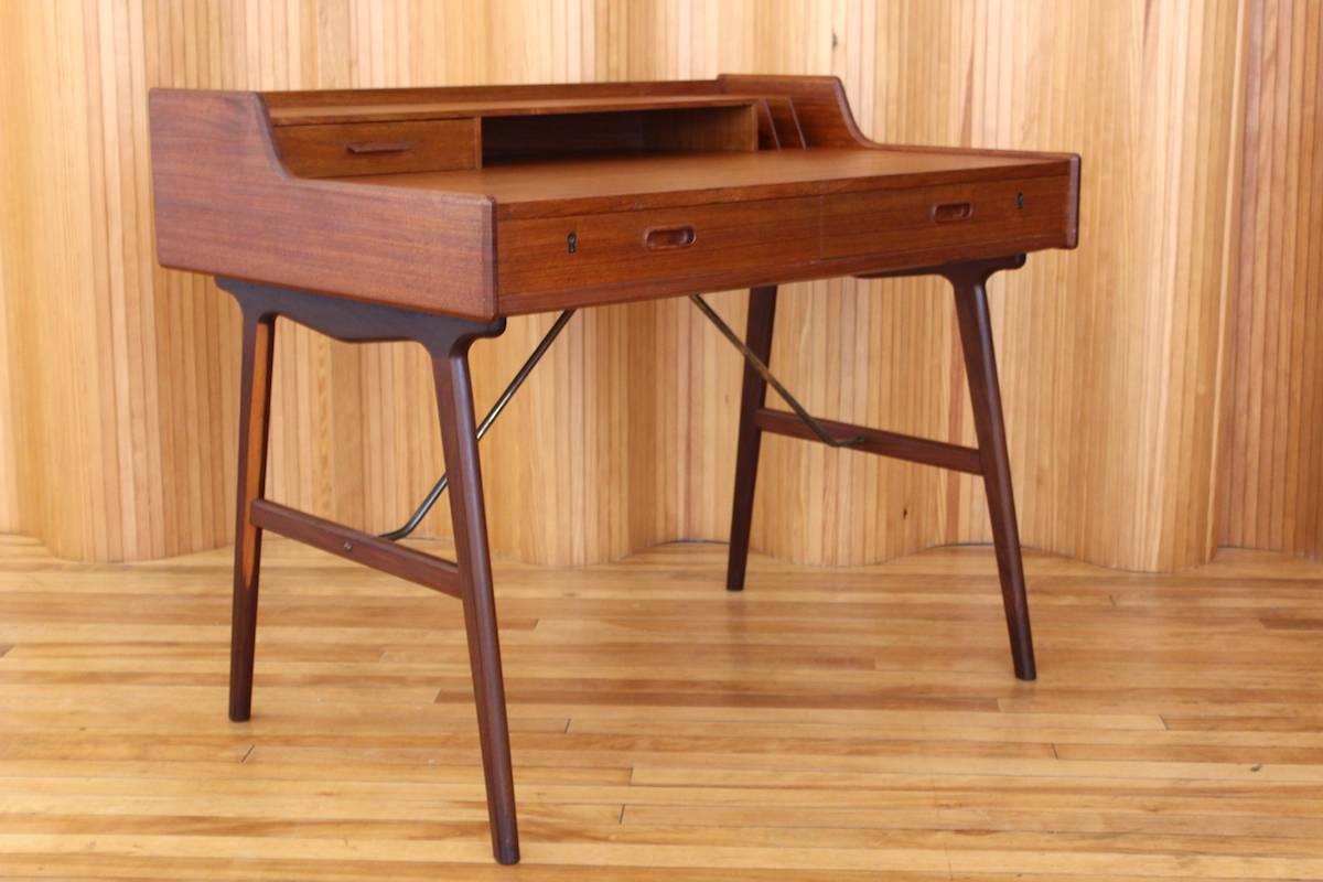 Description: Stunning teak desk, model 56. Lovely detailing and sweet proportions. Finished to the rear so it can freestand perfectly in a space. Comes with original key.

Designer: Arne Wahl Iversen

Manufacturer: Vinde Mobelfabrik,
