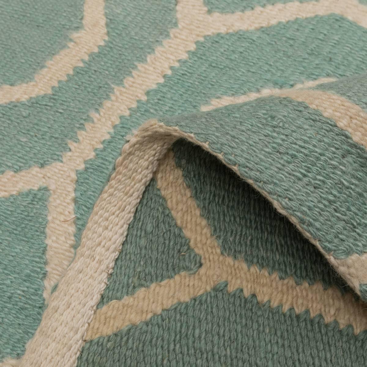 Contemporary Flatweave Rug with Geometric Desig over Green Background.