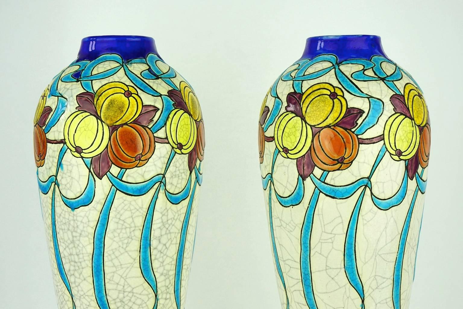 The design of this pair of vases specifically signed by Charles Catteau shows the permanence of some Art Nouveau patterns even after 1920, number 745. Form 683. It is polychrome with stylised gourds, leaves, twigs and ribbons on eggshell background.