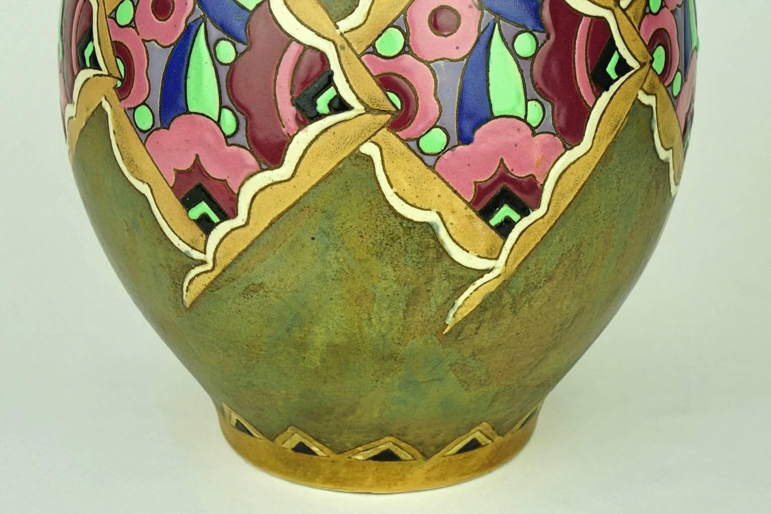 Rare Art deco Keramis vase with the belly decorated with a frieze of colorful stylized flowers in rhombuses on mat green background. (Design 1449).

Marks: F 963.

Material: Enameled stoneware.
