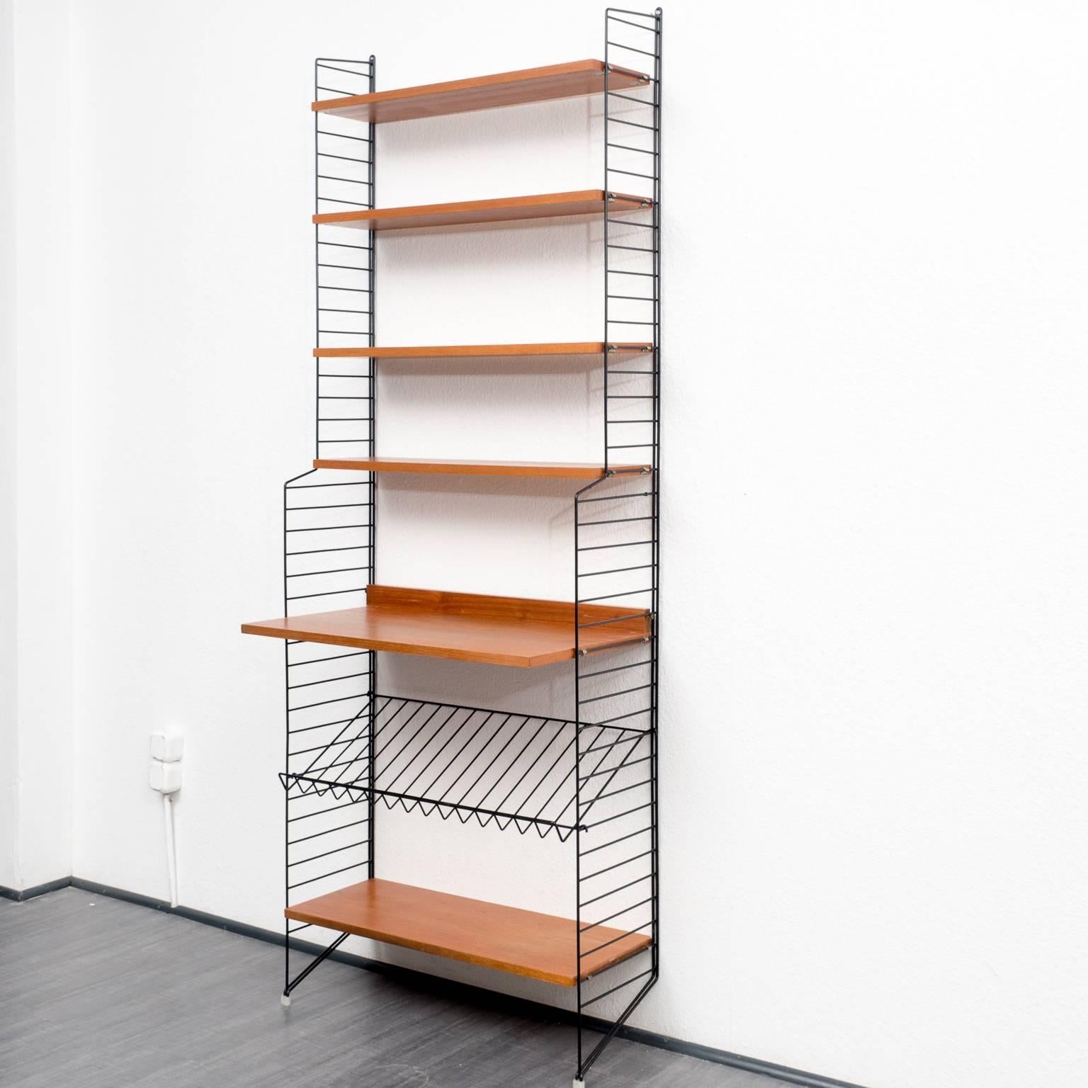 Classic shelf from the 1960s, design by Nisse Strinning. Rare version with long floor ladders, black metal. Teak-faced shelves. Good condition with small traces of usage.
