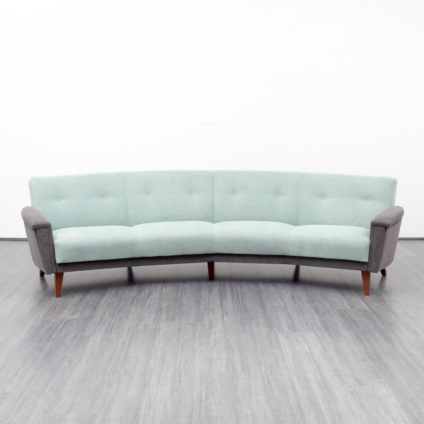 Beautiful couch from the 1950s in rare, large and semi-circular format. The original barrel-arbour has been professionally reupholstered and newly covered with high-quality upholstery fabrics in two colours. The seat is light turquoise; armrests and