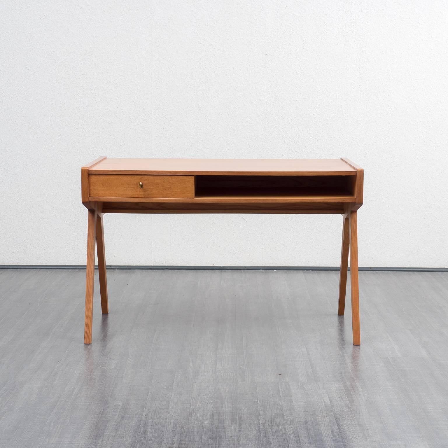 A rare design classic from the 1950s: shapely desk based on a draft by Helmut Magg, 1952, for Vereinigte Werkstätten. Walnut veneered carcass, very good workmanship. One lockable drawer, one open compartment and a practical bookshelf at the back.