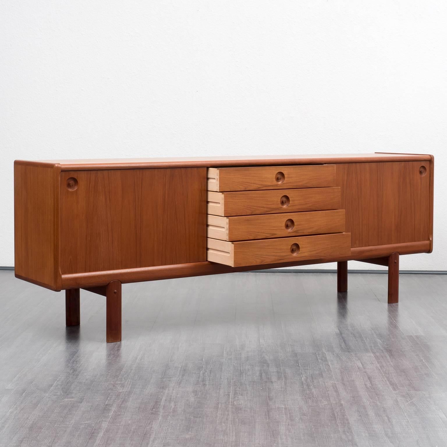 High-quality 1970s sideboard by Bramin, Danish design. Partly solid teak version with two sliding doors, four drawers and beautiful handles. The sideboard is free-standing due to a veneered back side.

Good condition with small traces of usage.