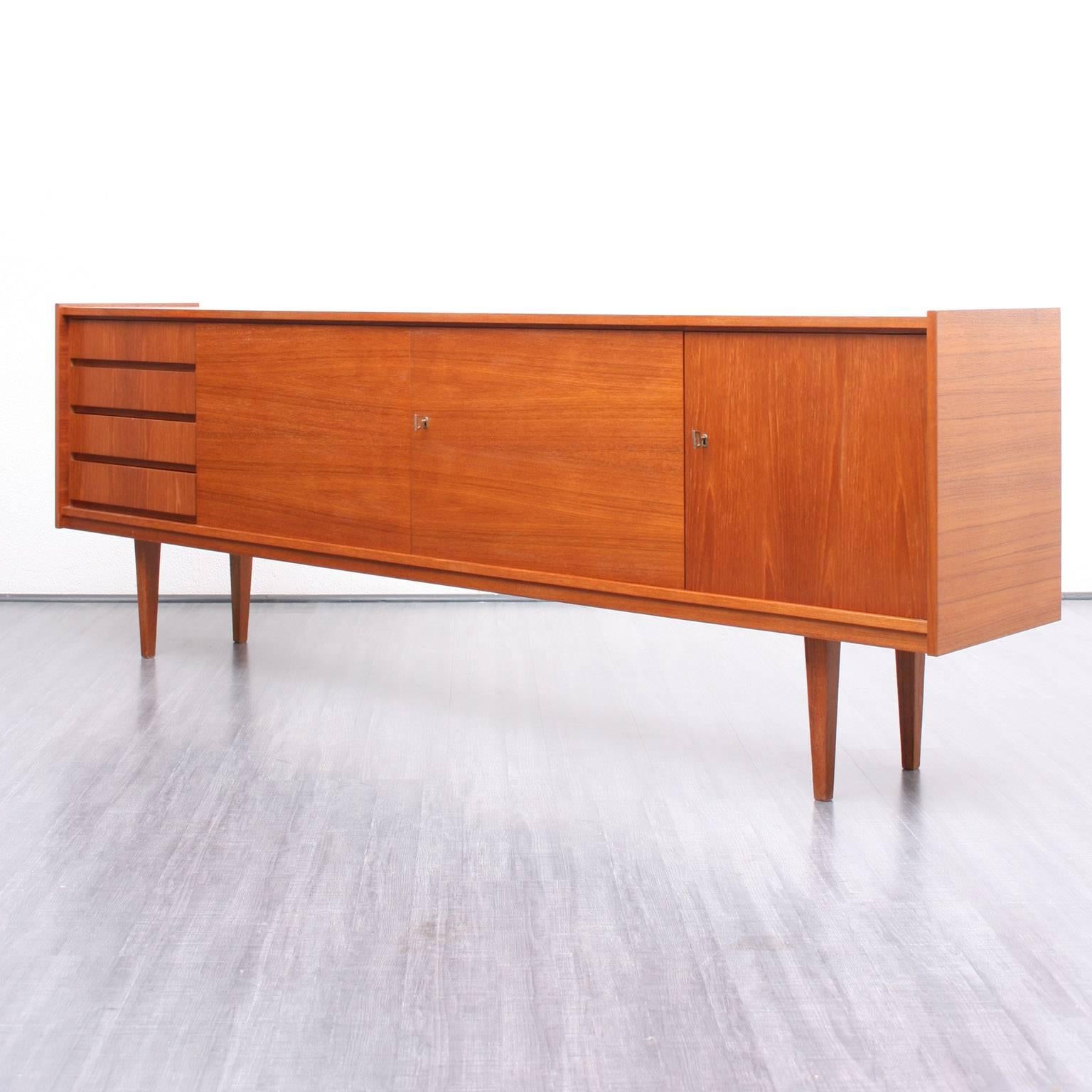 Classic sideboard from the 1960s in Scandinavian design. Very good workmanship. Straight-lined, elegant design with teak veneer and pointy legs.

Very good original condition with small traces of usage.