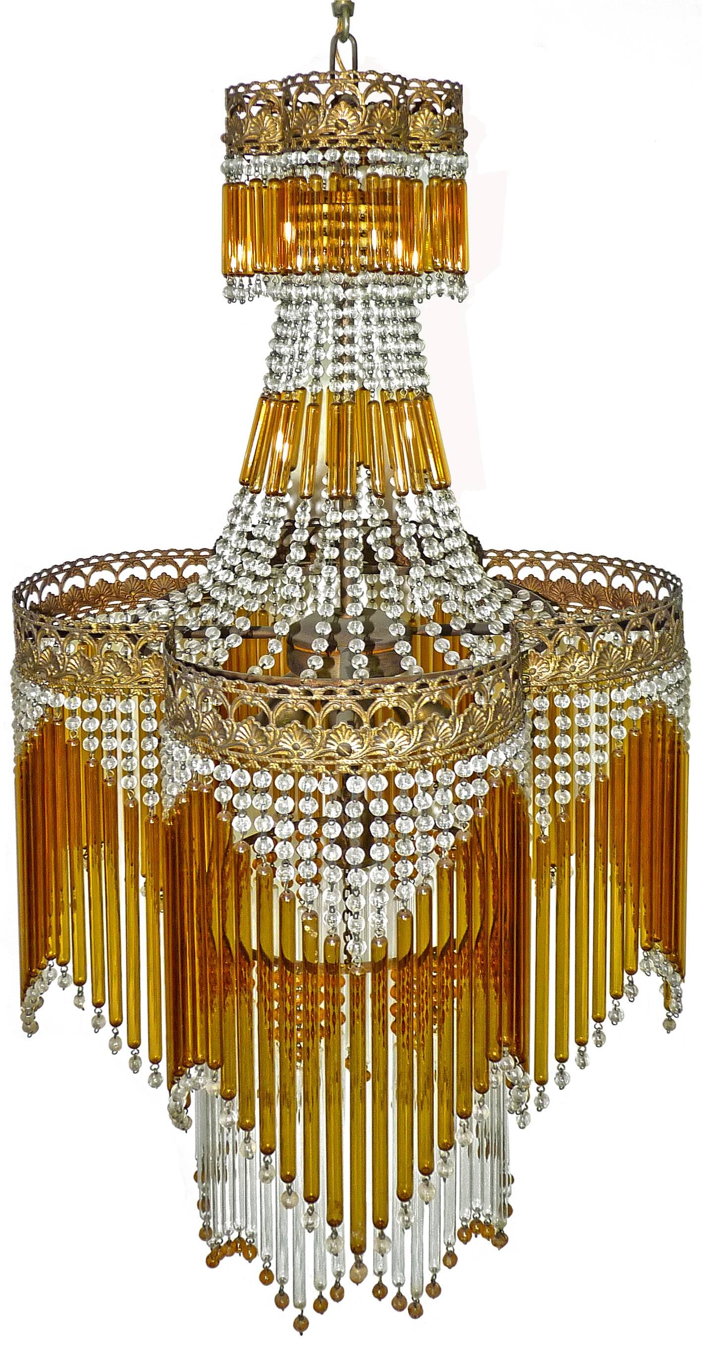 Fabulous Italian Mid-Century in clear and amber Murano beaded glass Art Deco / Art Nouveau chandelier
Measures: Diameter 40 cm
height 95 cm
Five light bulbs E14/ good working condition/European wiring.
Age patina
Also have matching chandeliers