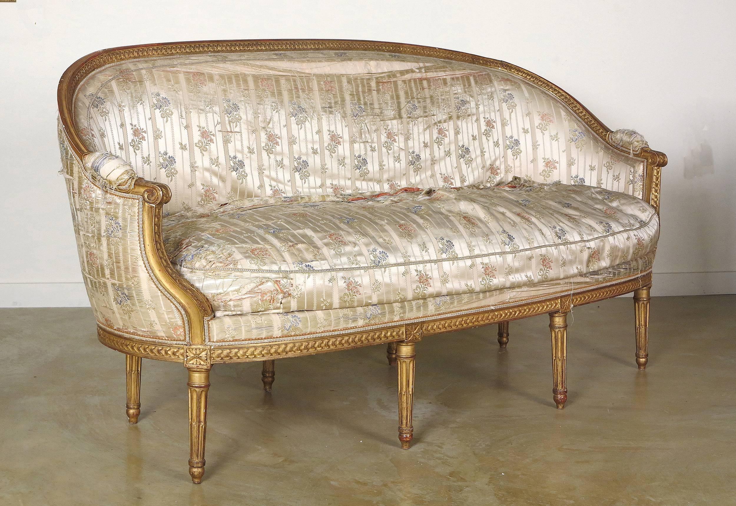 A fine Louis XVI giltwood Canapé En Corbeille
By Claude I Sene, 
18th Century

The guilloche-carved top rail, continuing to the sides with padded armrests, raised on foliate carved incurved supports, above the bow-fronted seat with loose