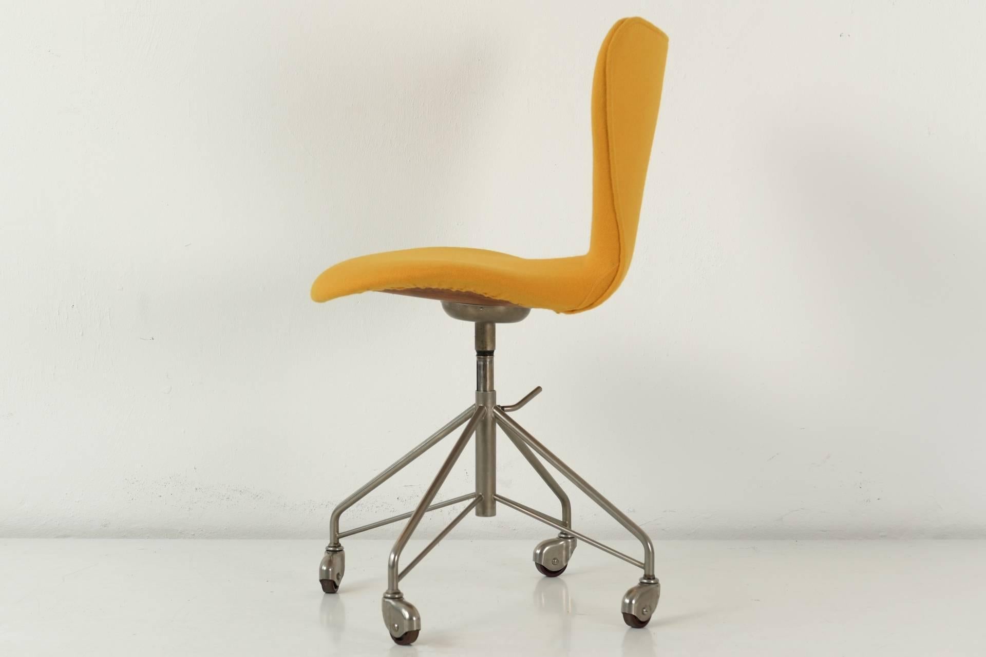 In the earliest version from the 1950s, we offer this classic by Arne Jacobson as a desk chair on wheels. The nickel-plated frame on castors, the assembly without side struts and the embossed metal cap under the seat represent the first version. The