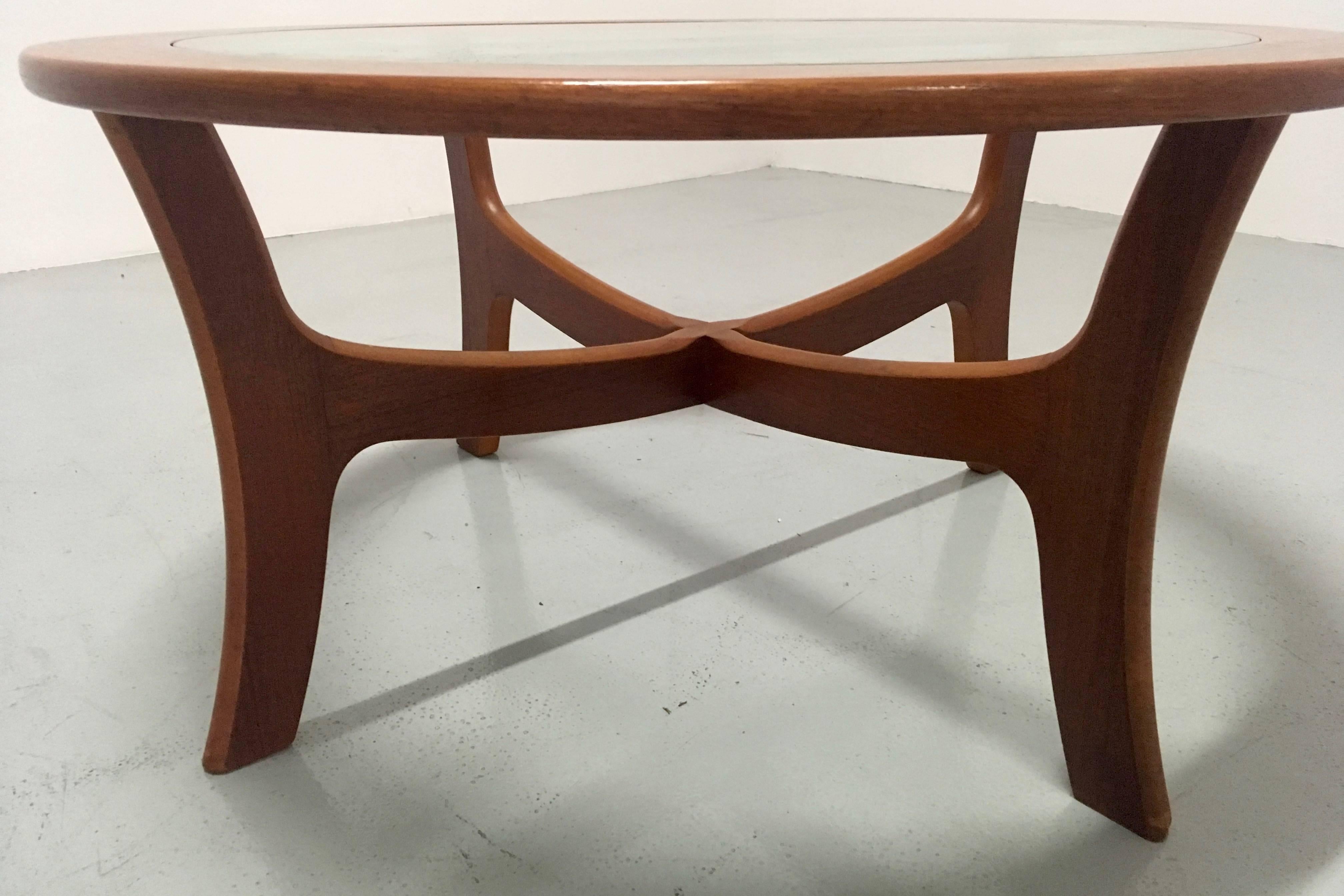This elegant round coffee table is made of solid teak and comes with a glass top. It was designed in the 1960s with a clear Danish influence. It was produced by G-Plan in the 1970s.