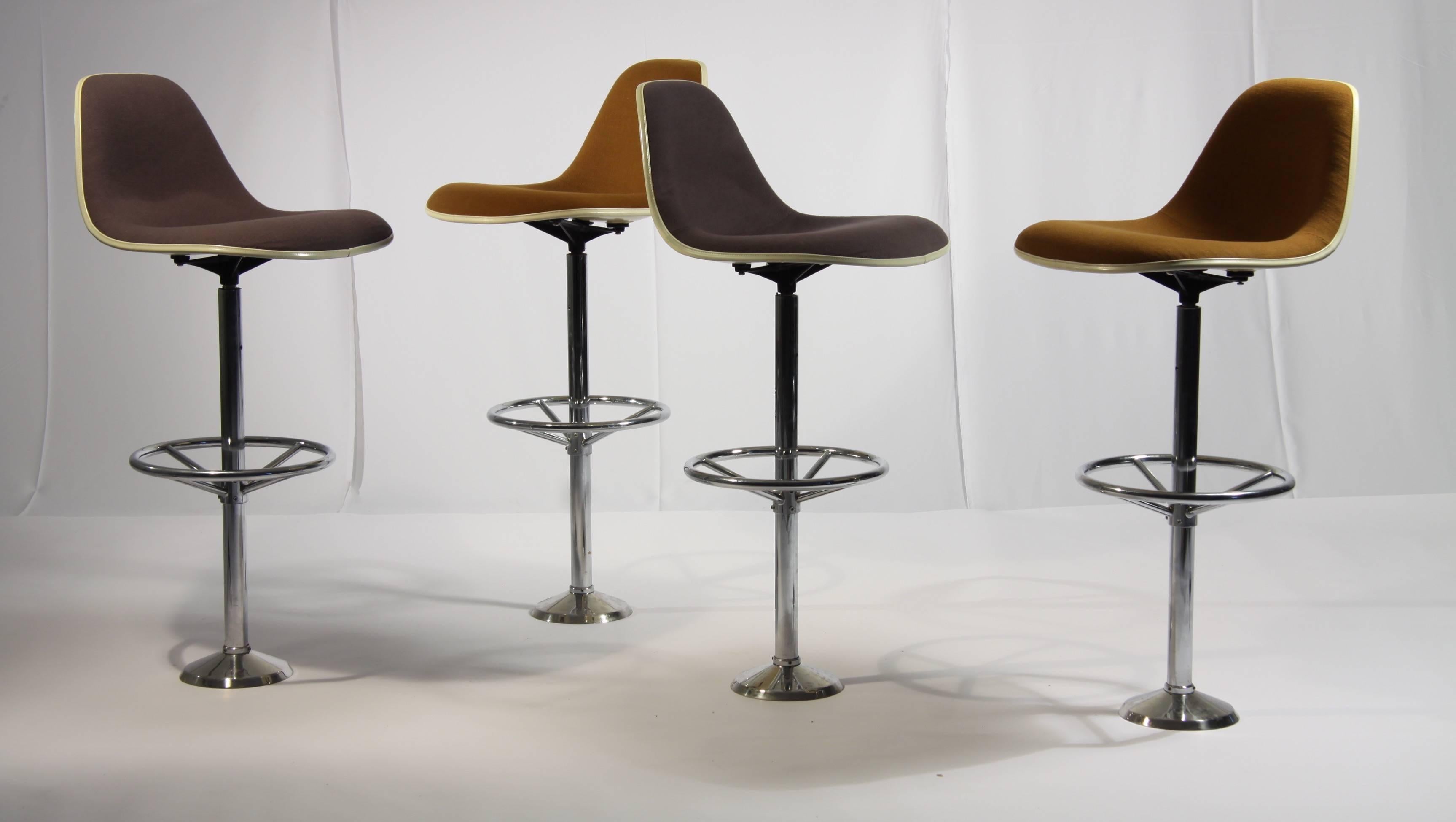 These bar stools made from brown Hopsack on a polyester shell standing on a bolted chromed column were designed by Ray & Charles Eames.