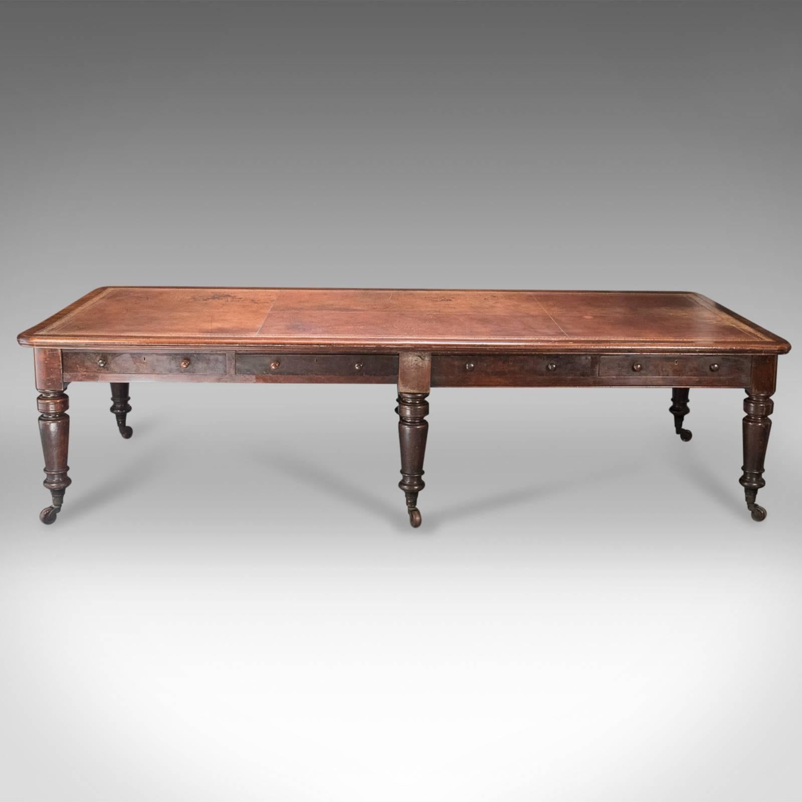 This is a very large antique library table dating to the mid-19th century.

Rare to find in such large proportions, this table stands upon six stout baluster turned legs, riding upon the original grand ceramic castors in brass cups. 

Four