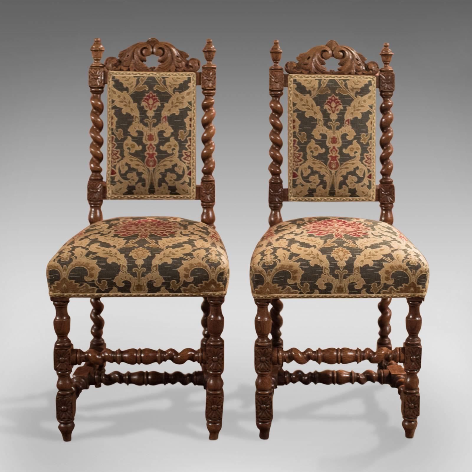 This is a super pair of antique hall chairs dating to the mid-Victorian period, circa 1870.

In English oak with warm tones and an aged patina
Raised on tulip feet, front legs vase turned
Turned, barley twist rear legs and stretcher
Boxed