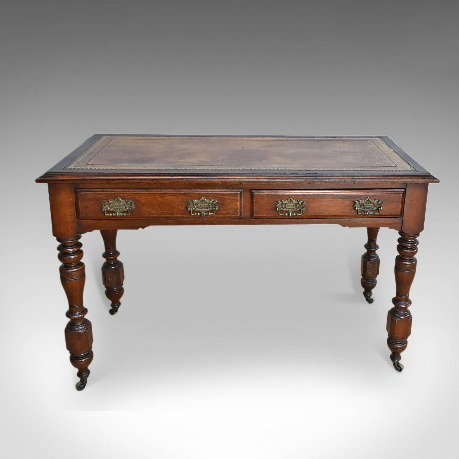 This is an attractive antique desk/late Victorian writing table dating to the end of the 19th century, circa 1880.

Crafted in oak with good color and an aged patina
Inset tan leather skiver twin tooled in gold
Raised on stout, turned baluster