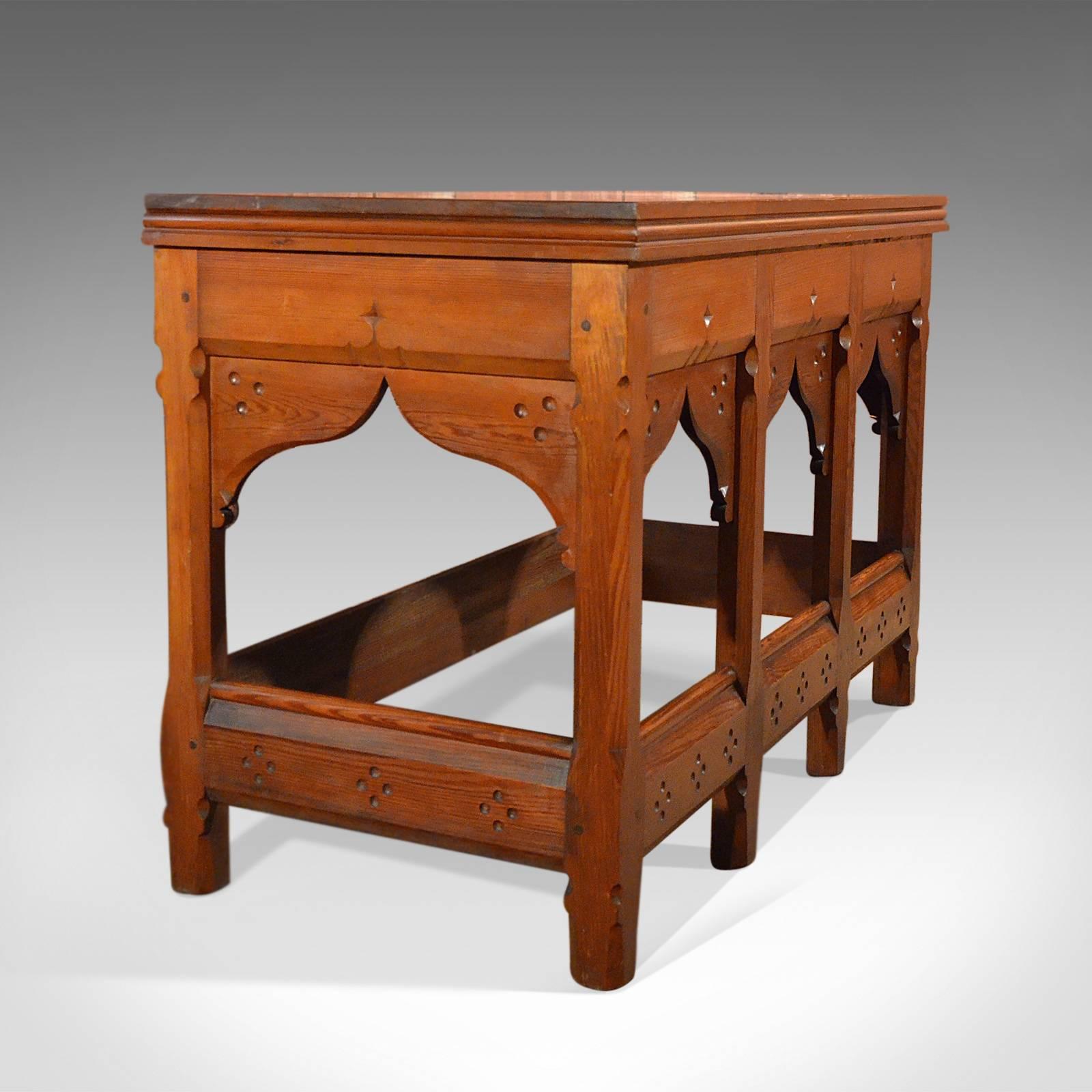 This is a large antique pitch pine serving table.

Substantial and honest this arts and crafts serving table has Pugin overtones with Gothic Revival style and artisan simplicity in the construction and design.

The pitch pine has an almost